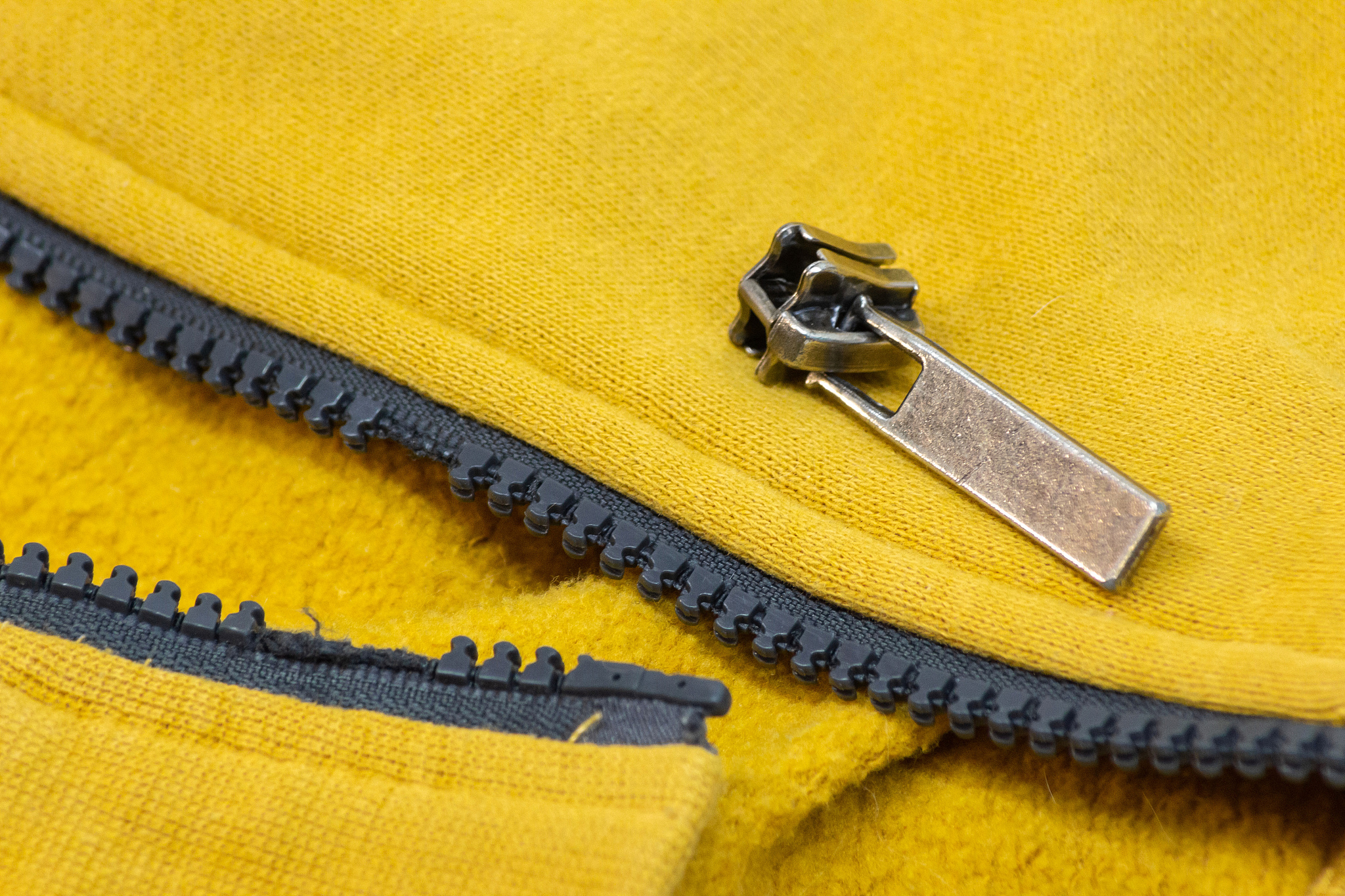 broken zipper on yellow shirt jacket. detail close-up photo.