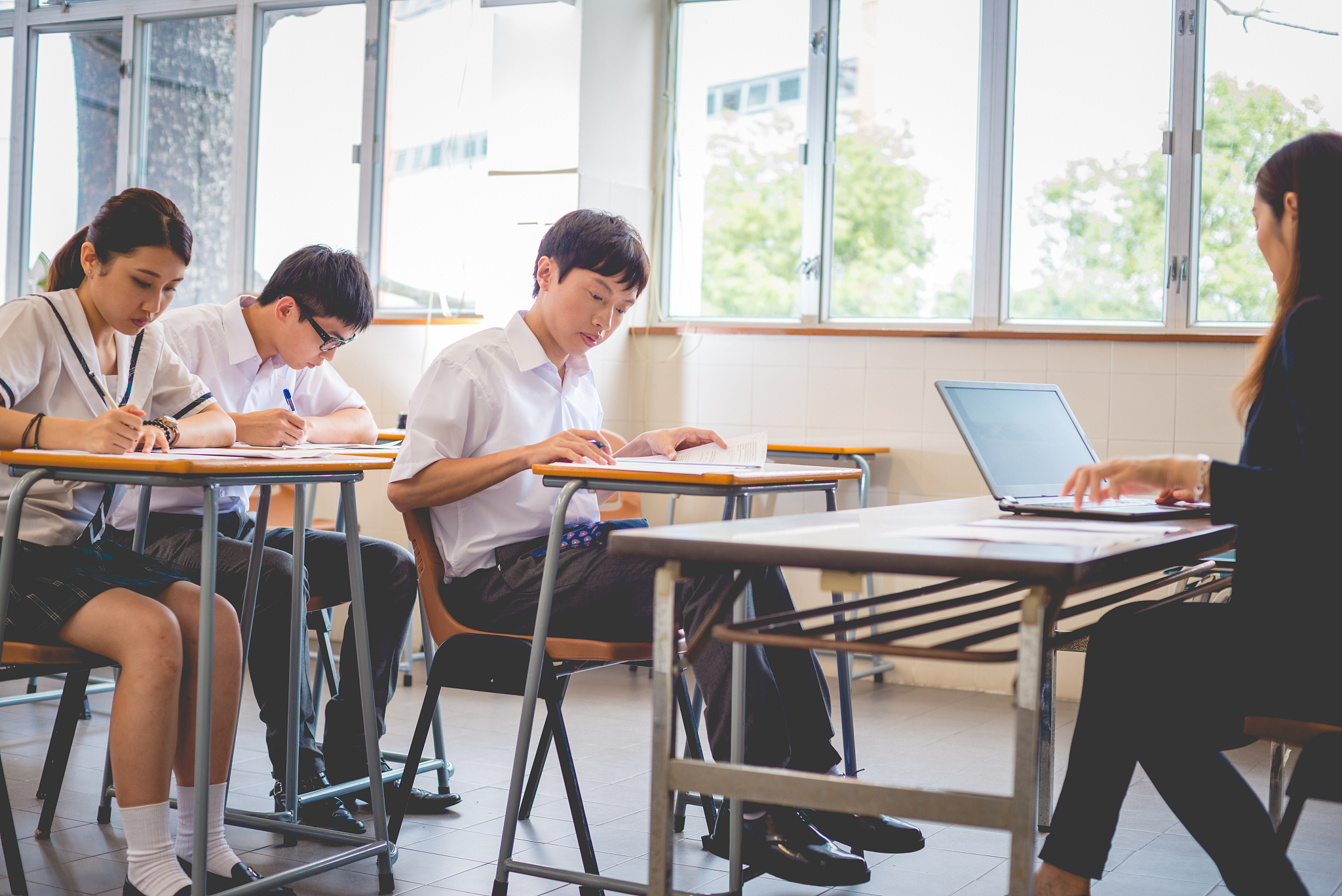 teacher surveying physics exam, hong kong school, asia