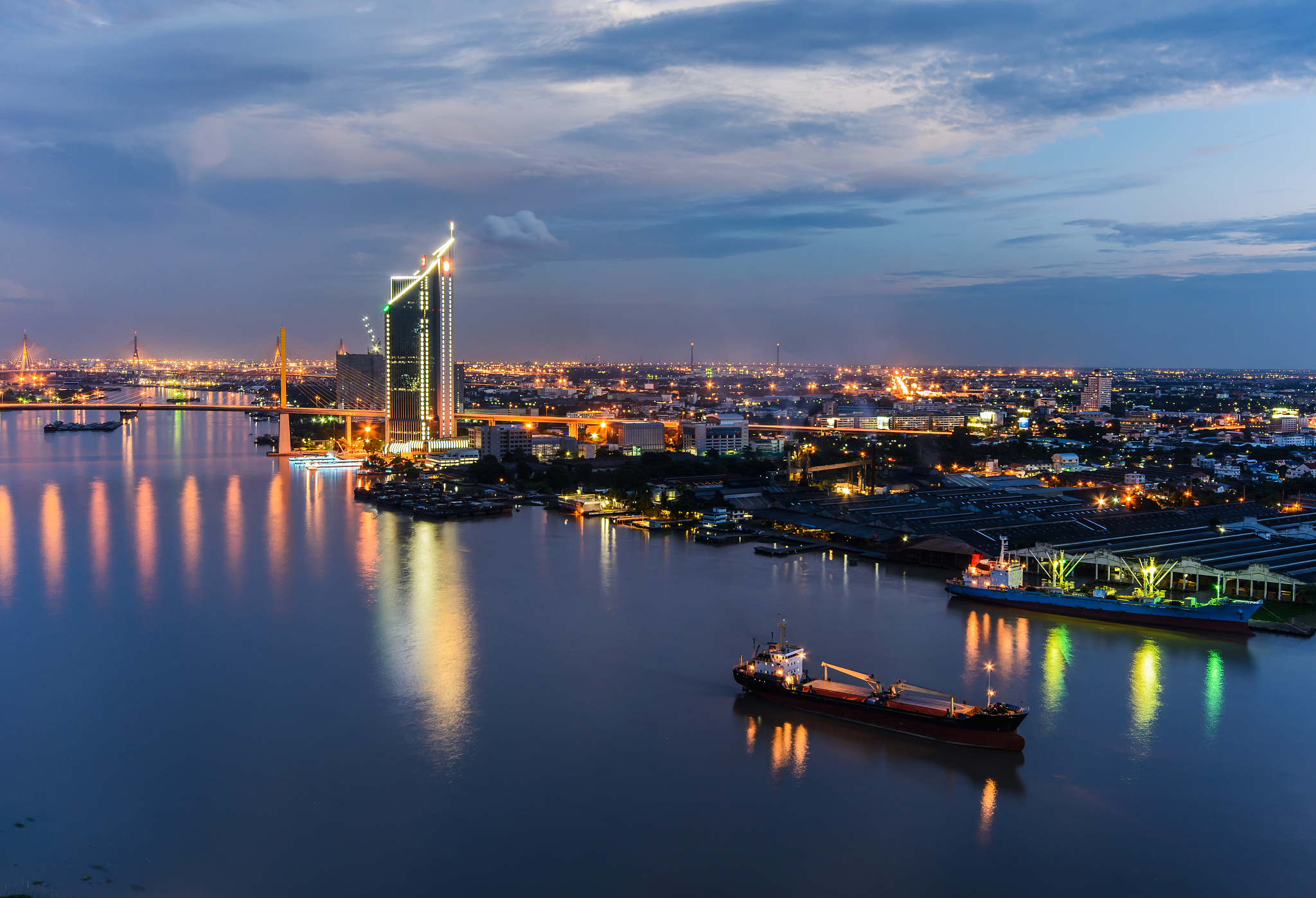 the bridge across the river with modern building at dusk.