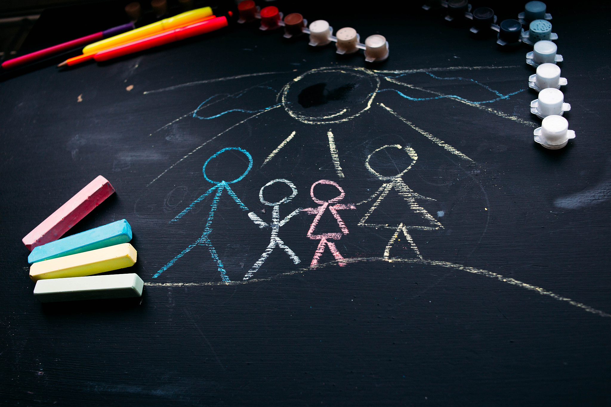 child's family drawing on a chalkboard in school. crayons for dr