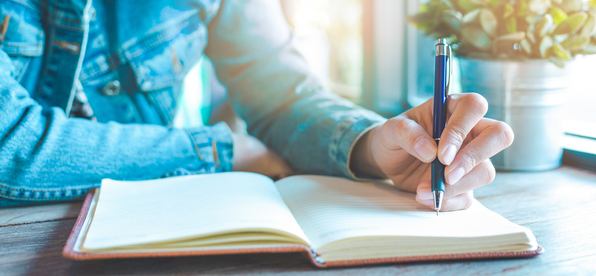 woman hand is writing on notebook with a pen in the office.