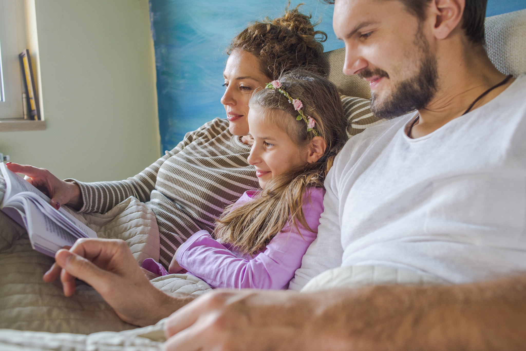 young parents reading with their daughter