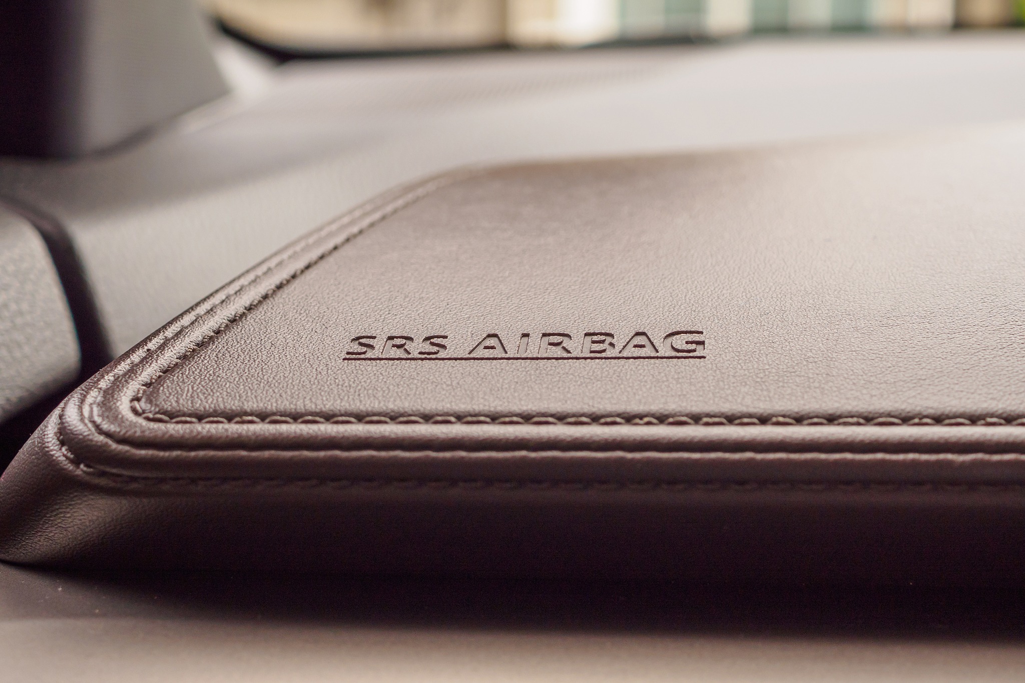airbag safety sign on brown leather texture in modern car