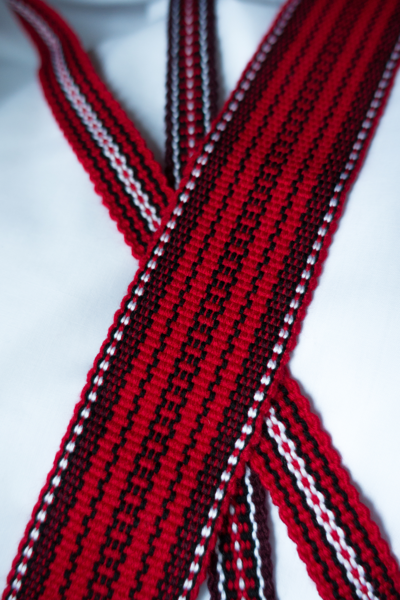three crossed woven tapes in with ethnic pattern in red, purple,