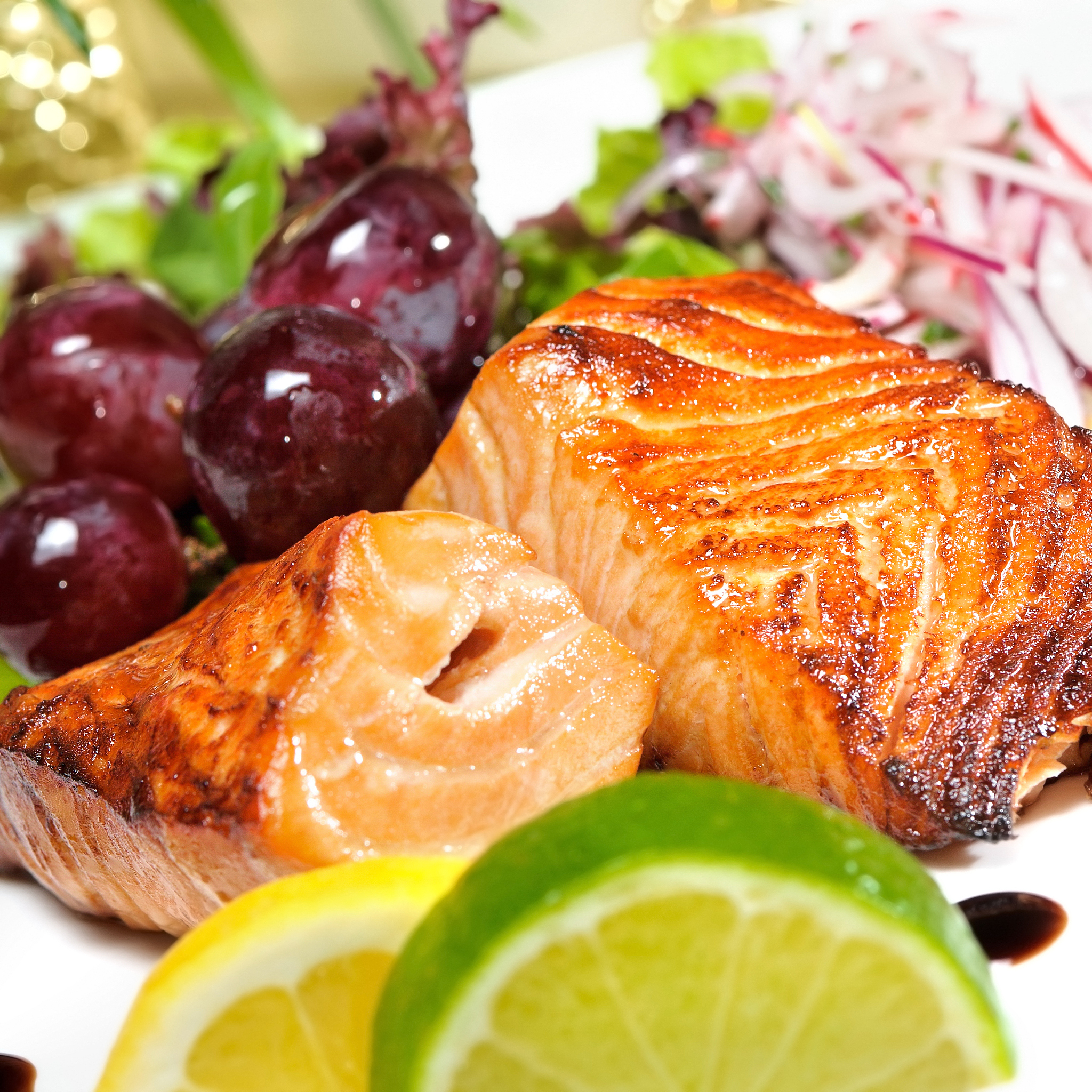 piece of grilled salmon, lettuce and lemon,grapes