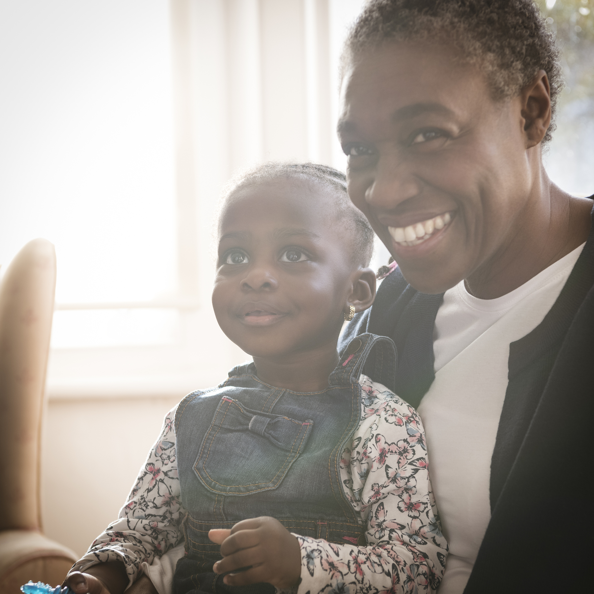 candid portrait of cheerful grandmother and cute granddaughter l