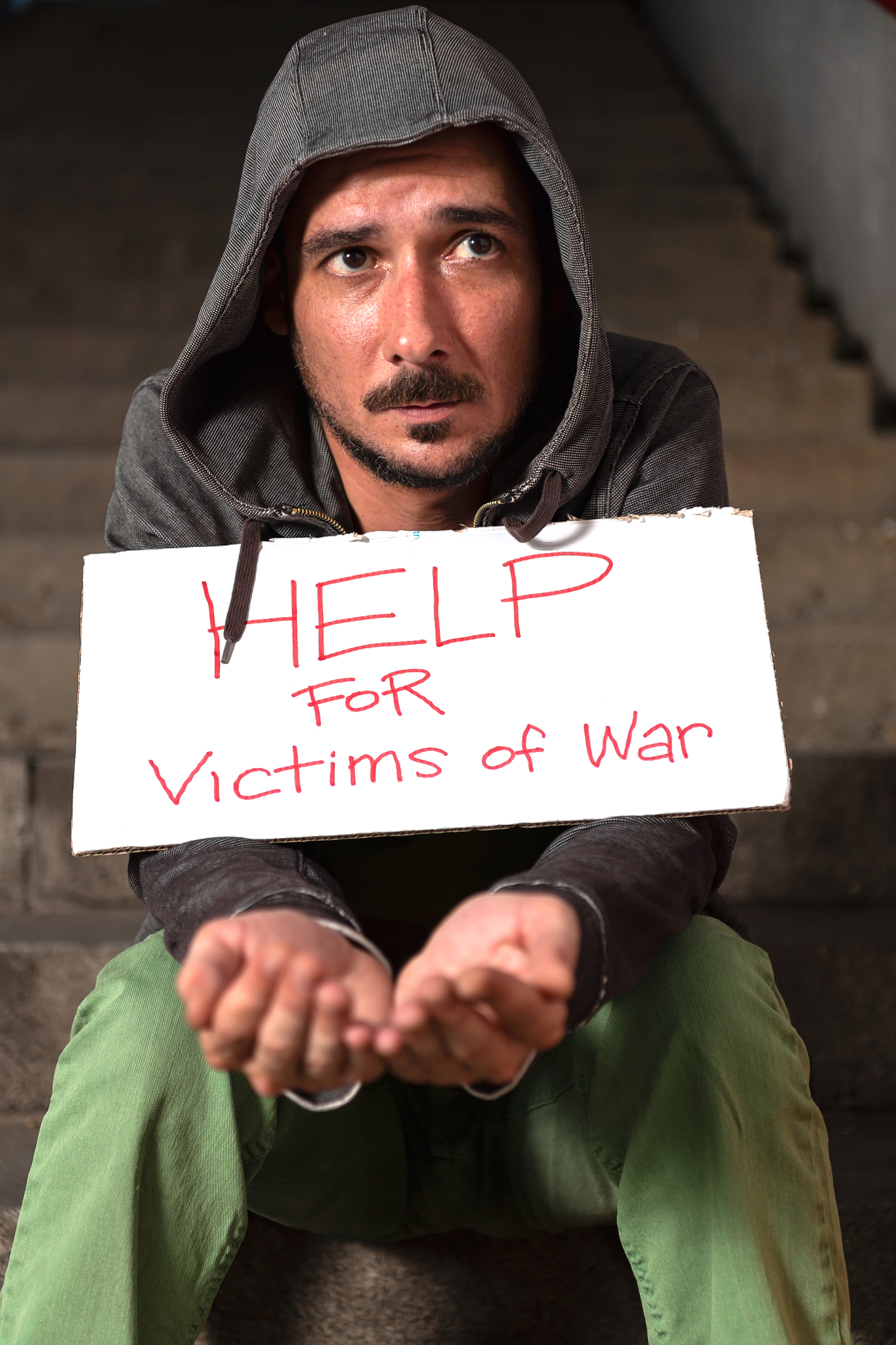 war veteran is sitting on the stairs and begging for help