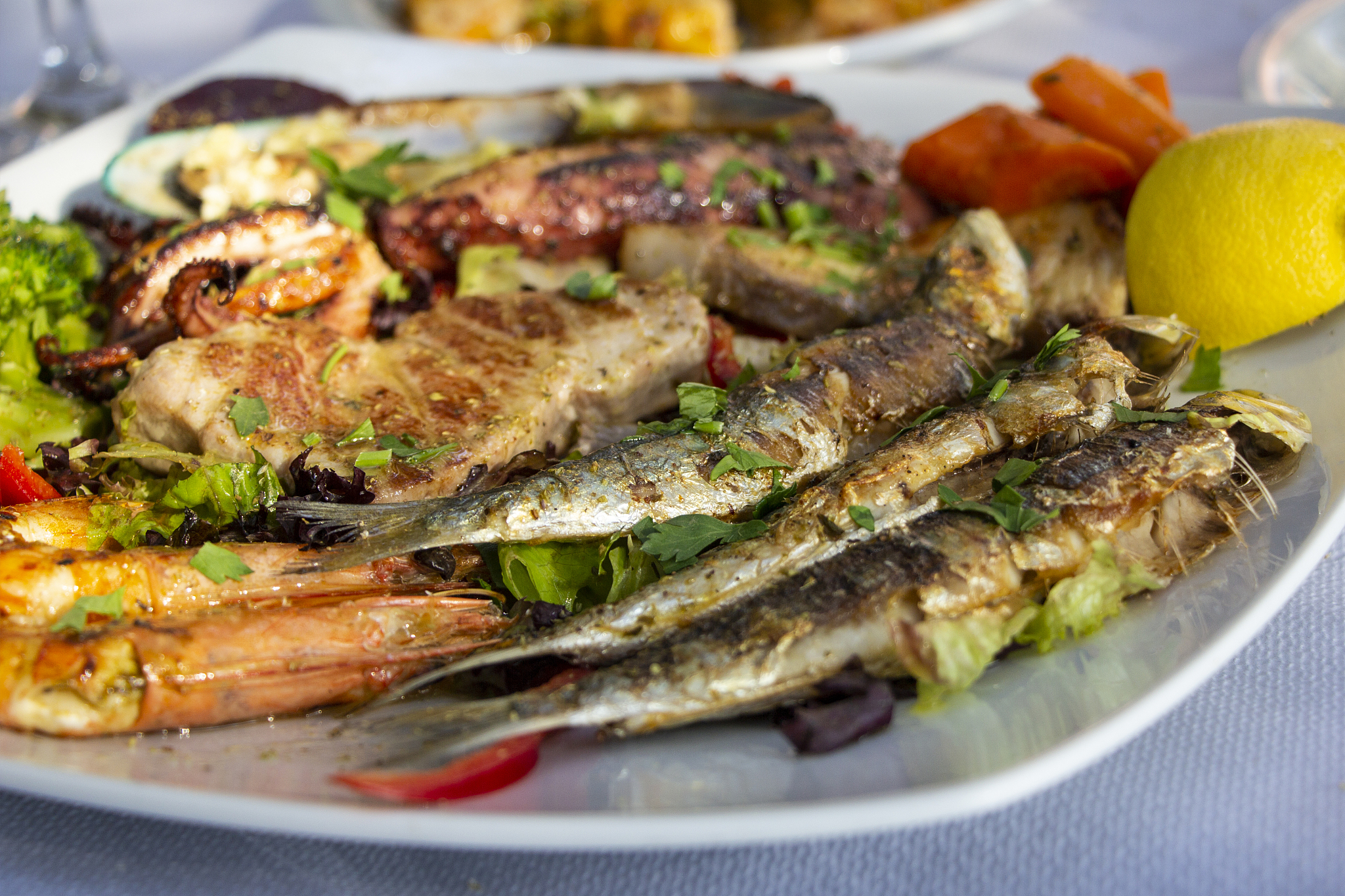 big plate with seafood, sepia, fish, shrimps, mussels served wit