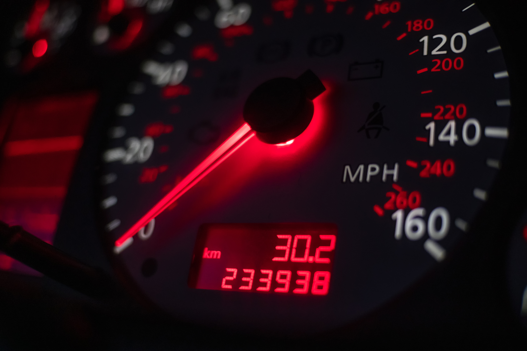 car dashboard. speedometer with red backlight at night close up