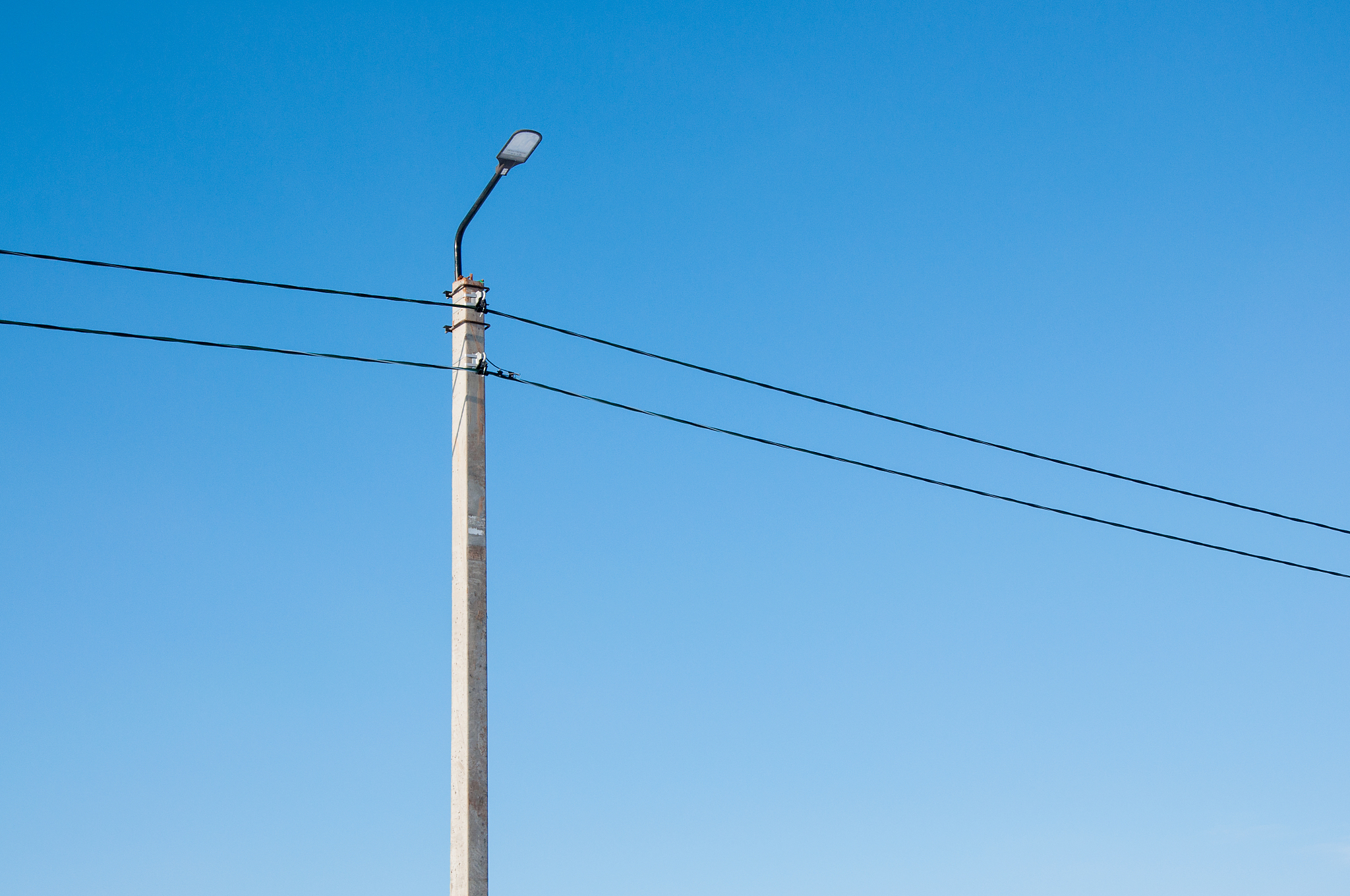 electric pole and high voltage wires against the blue sky. indus