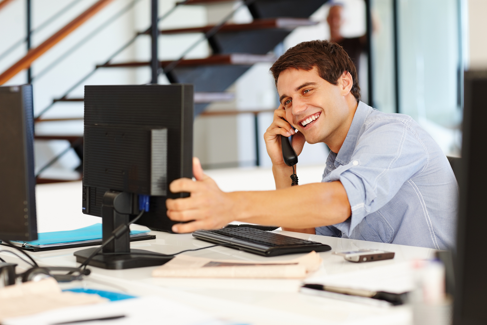 business man on call while looking at computer