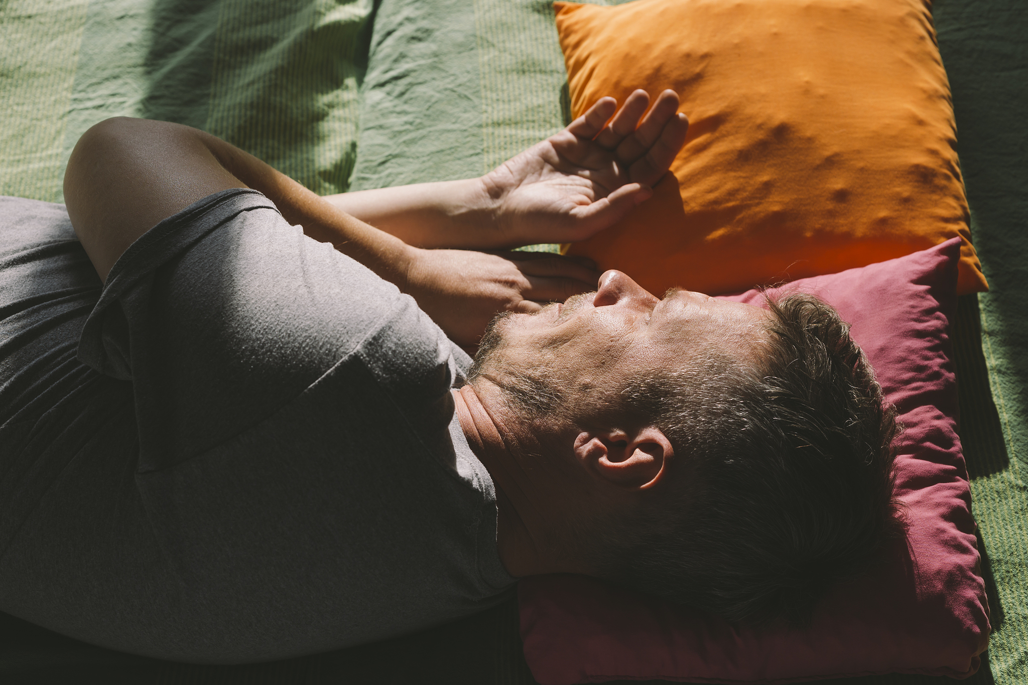 handsome adult man lying down in the bed and day dreaming, illum