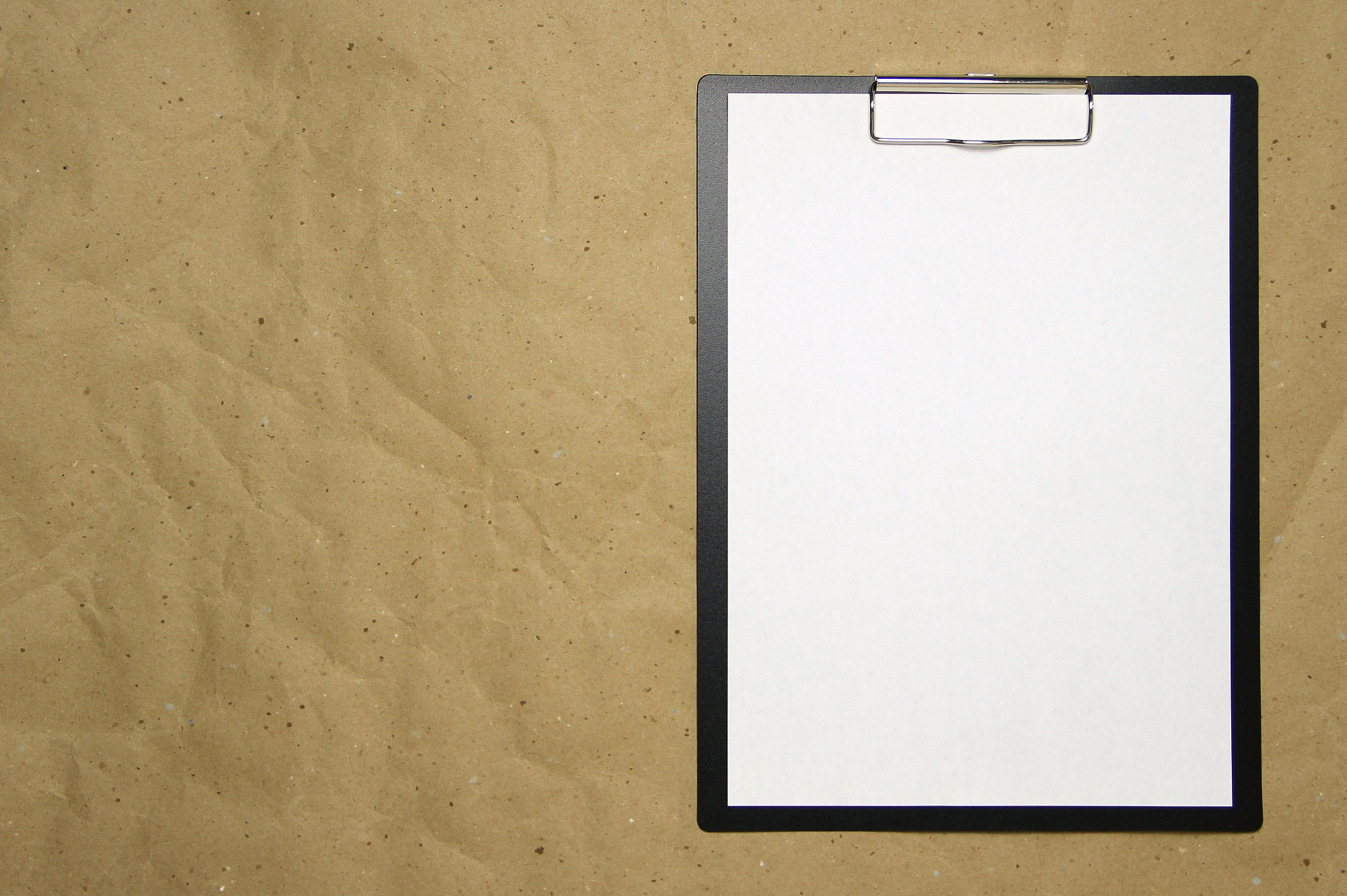a tablet with a white sheet of a4 format on a beige craft paper