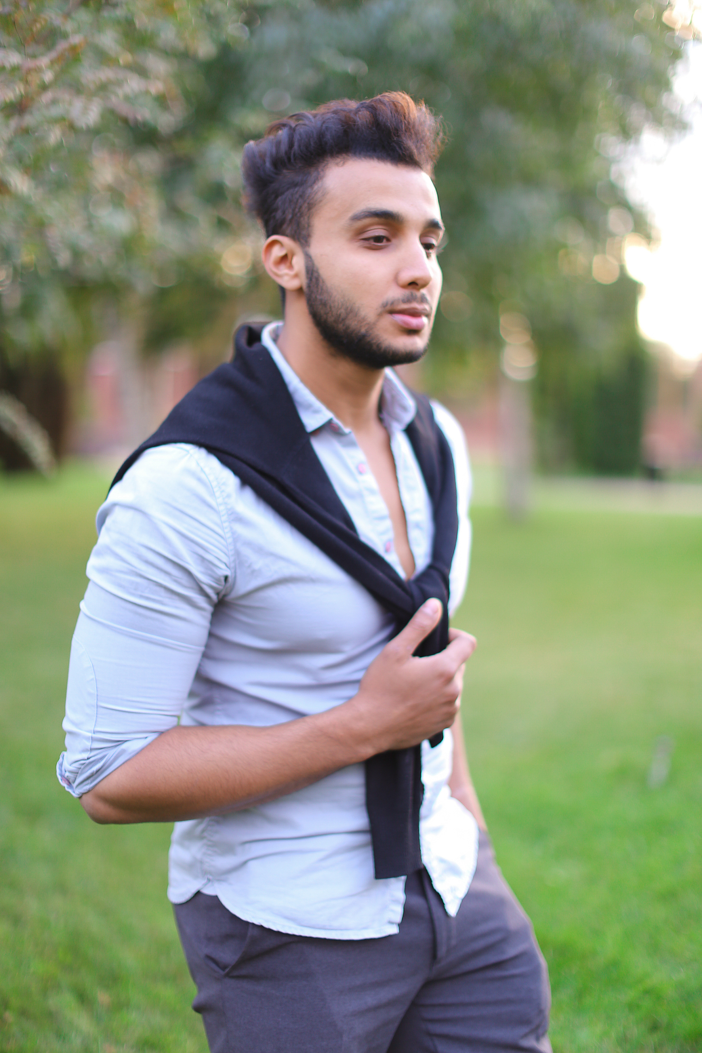 young handsome hispanic man walking in park