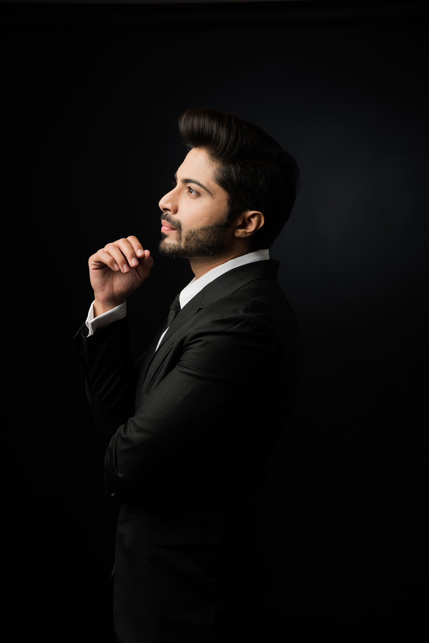 indian bearded male businessman showing side profile, standing o