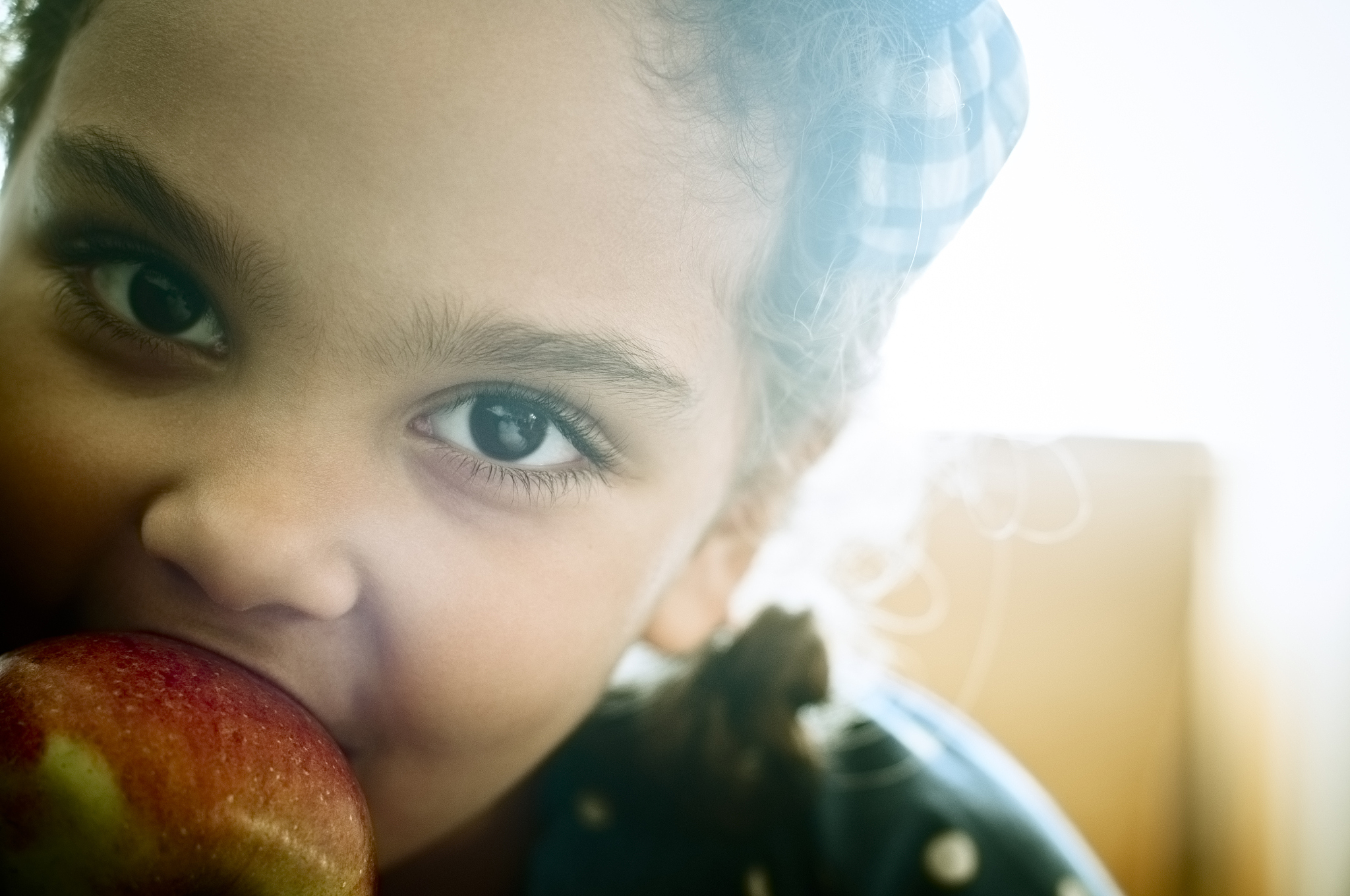 child (5-6) is eating an apple at home