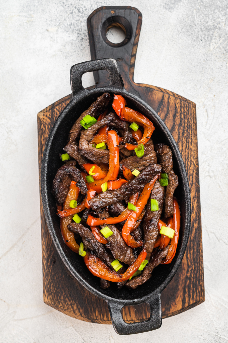 用辣椒和葱炒牛肉,在平底锅中烹制.受中国胡椒牛柳,条