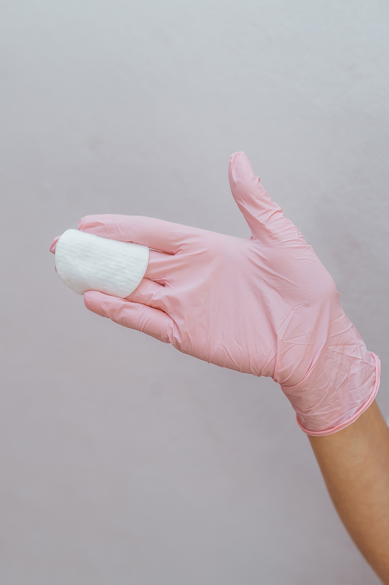 female hands in pink glove holding an face patch