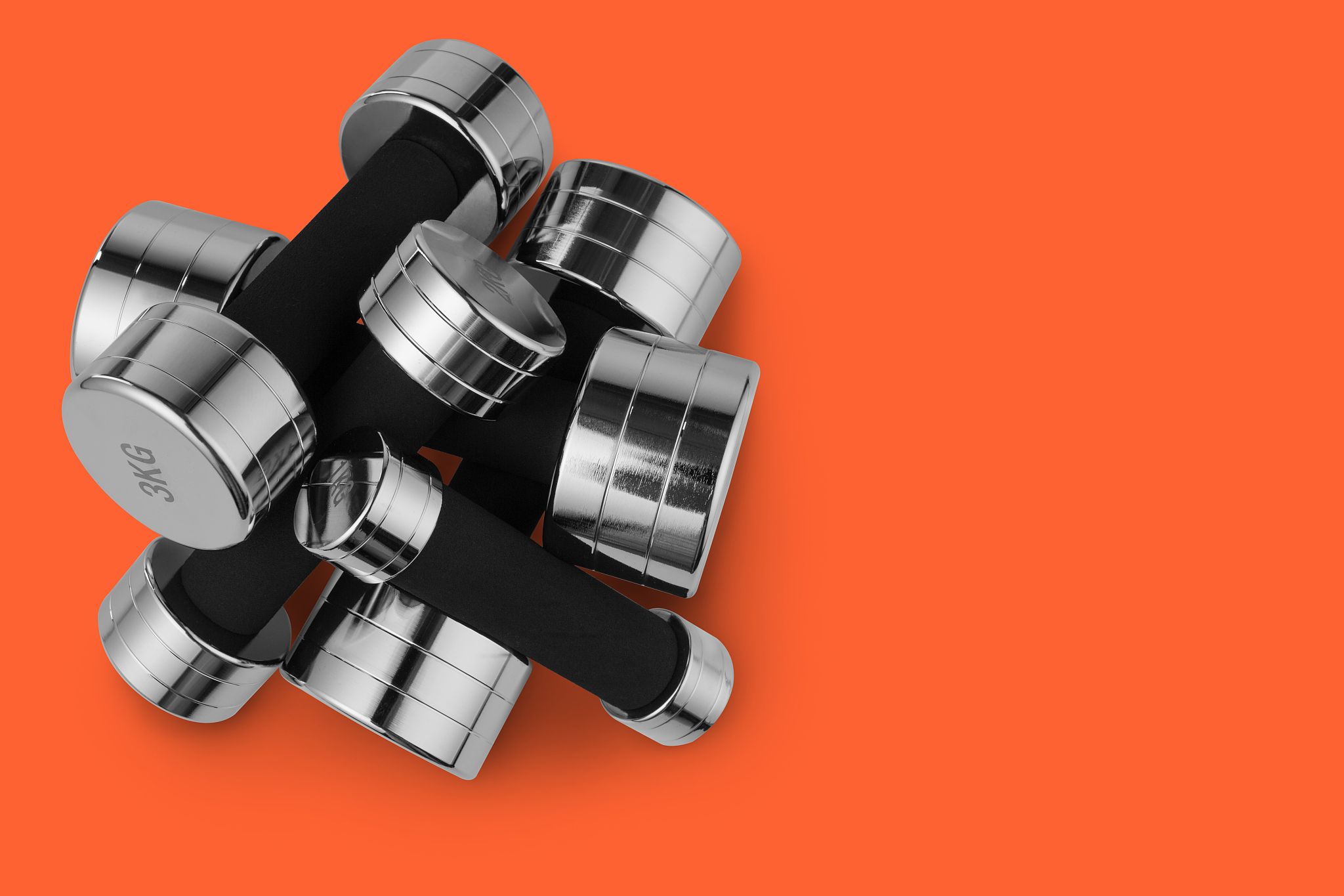 many steel chrome dumbbells lie in heap, on top of each other, s