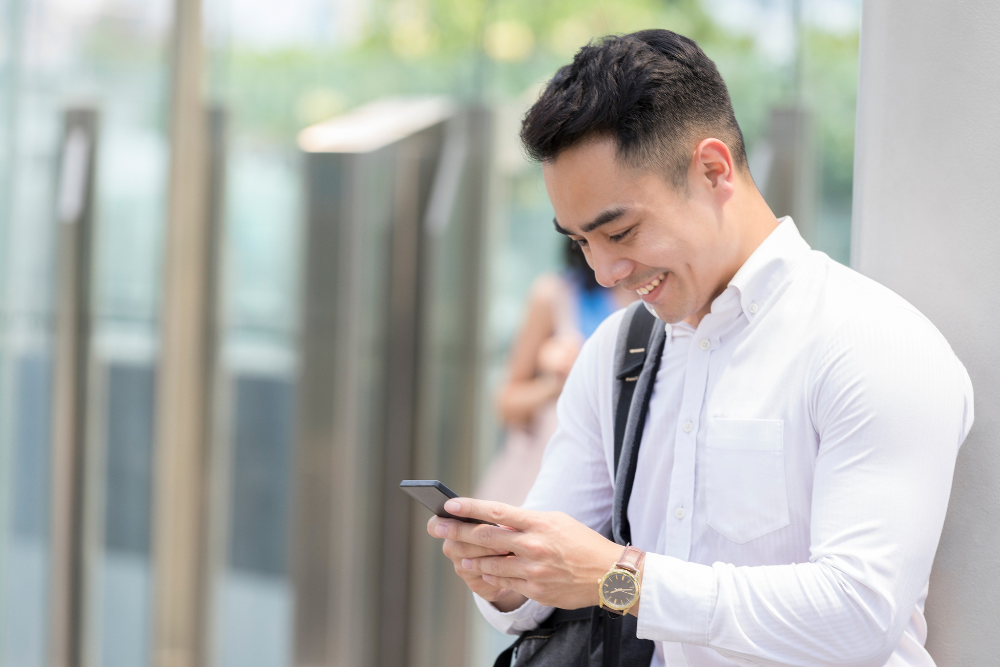 cheerful businessman video chats outside office building