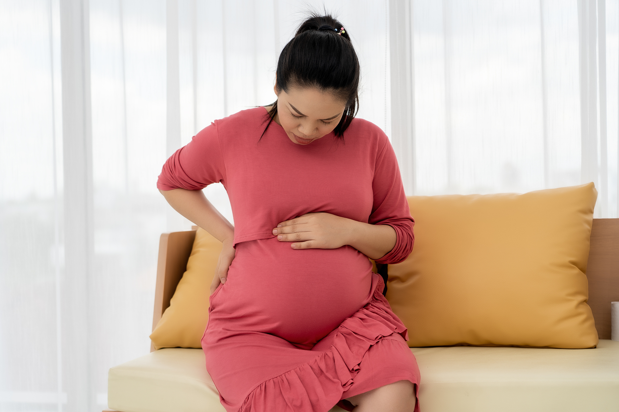 asian pregnant women feel back pain and discomfort.