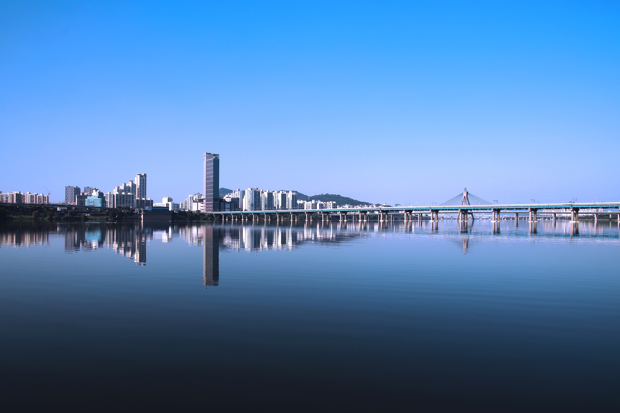 scenic view of lake by buildings against clear blue sky