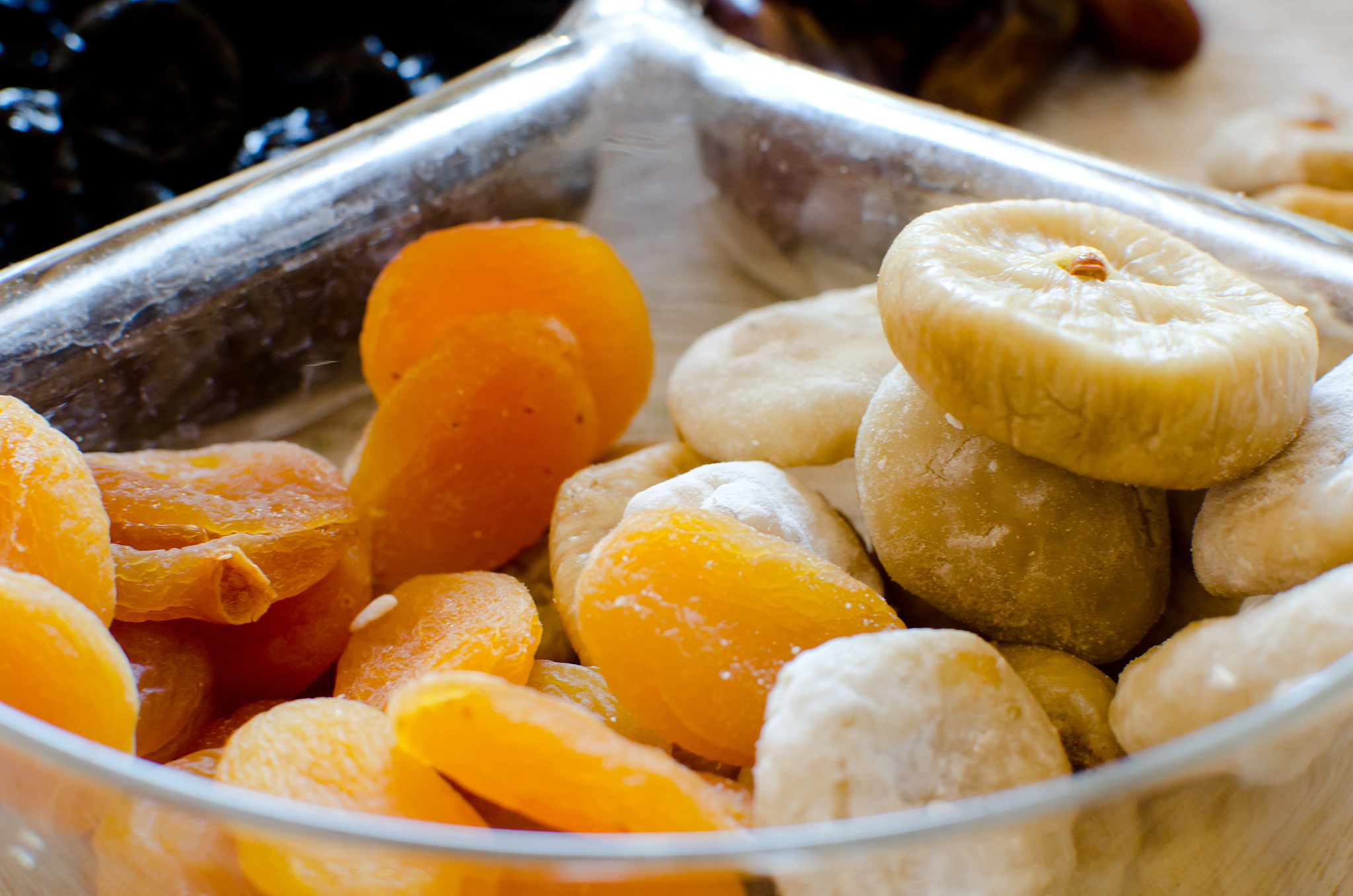 dried figs and apricots in glass transparent bowl