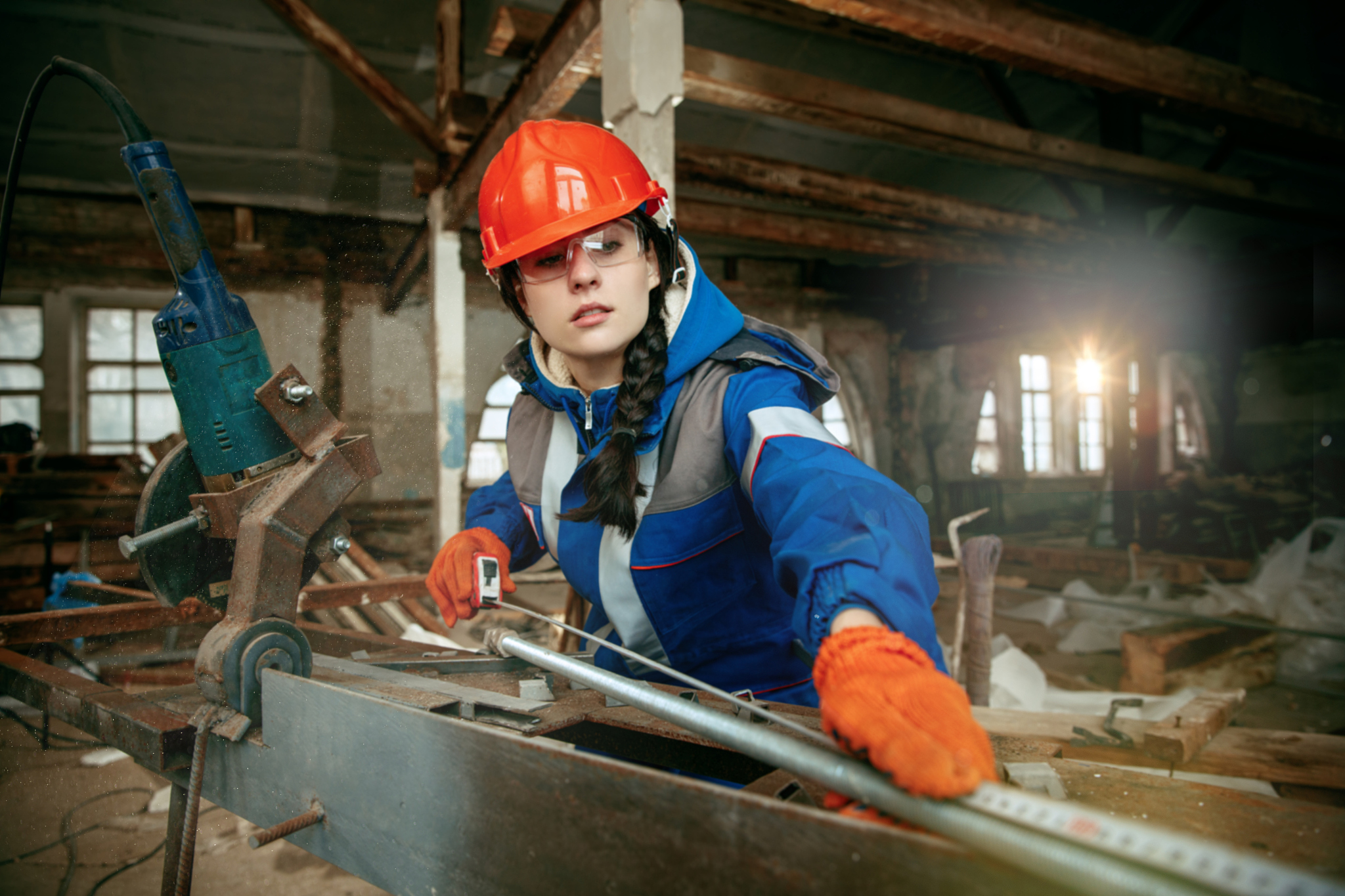 woman wearing helmet using male work tools