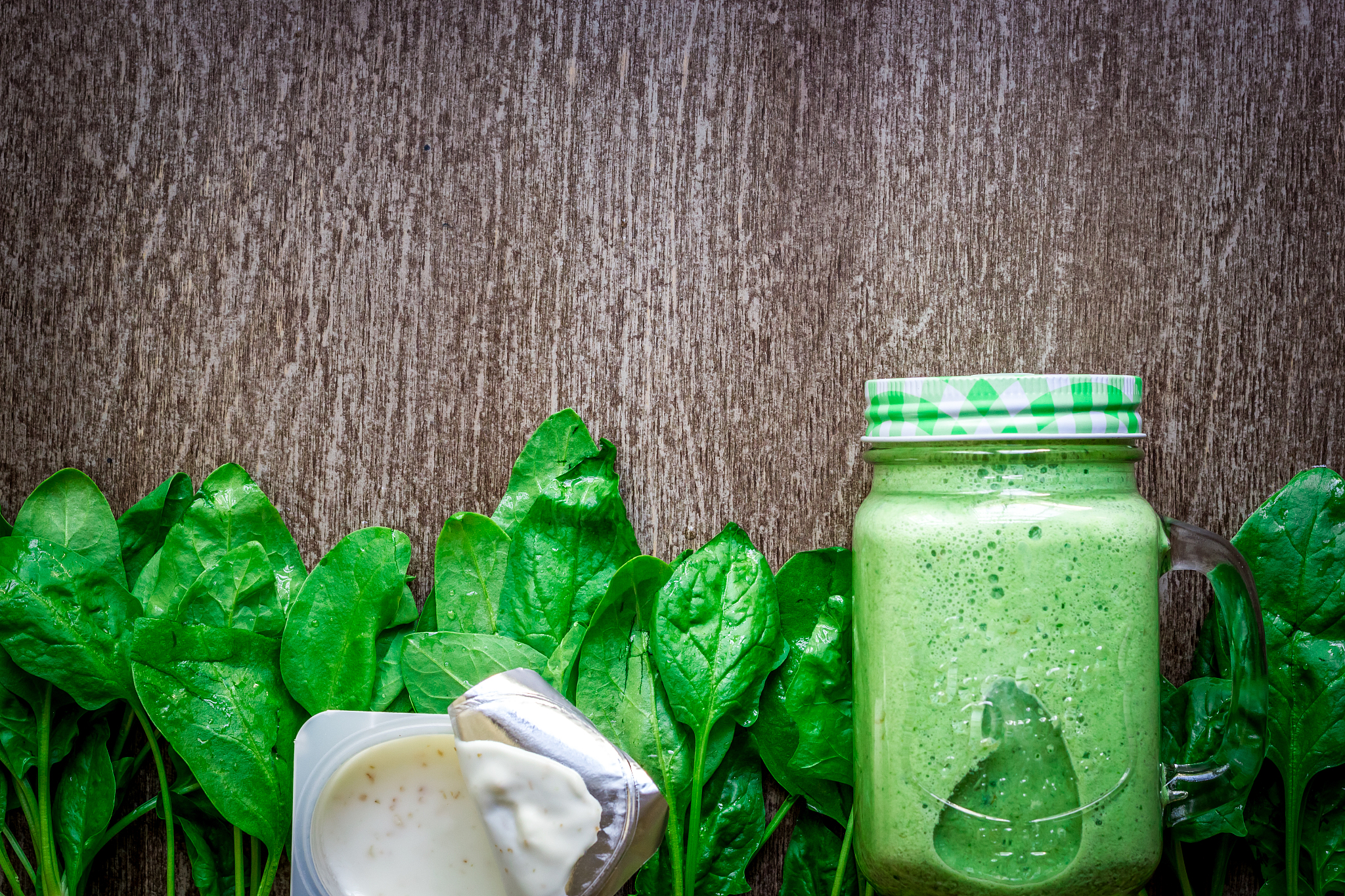 glass of spinach juice on wooden background