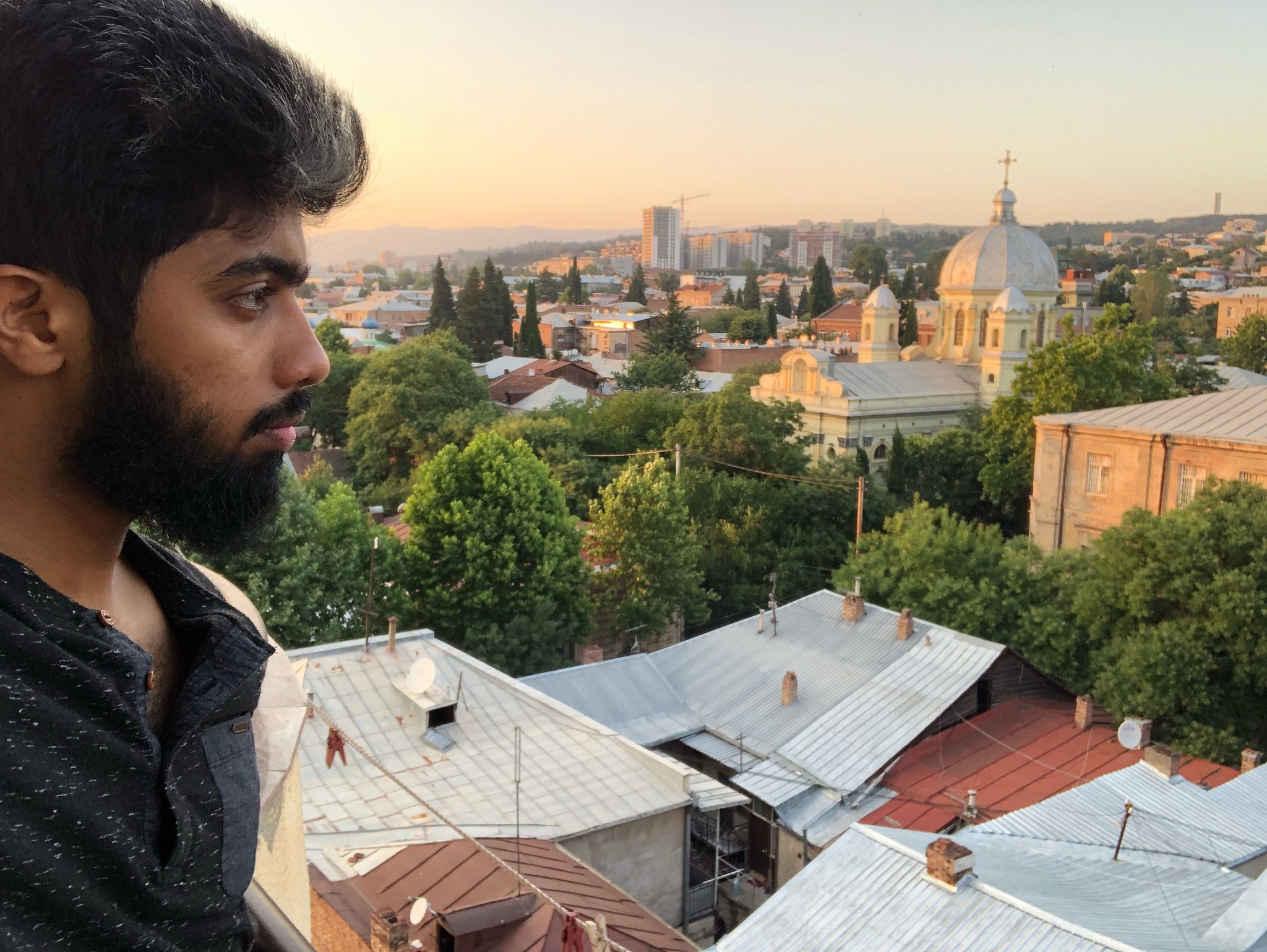 man looking at city against sky during sunset