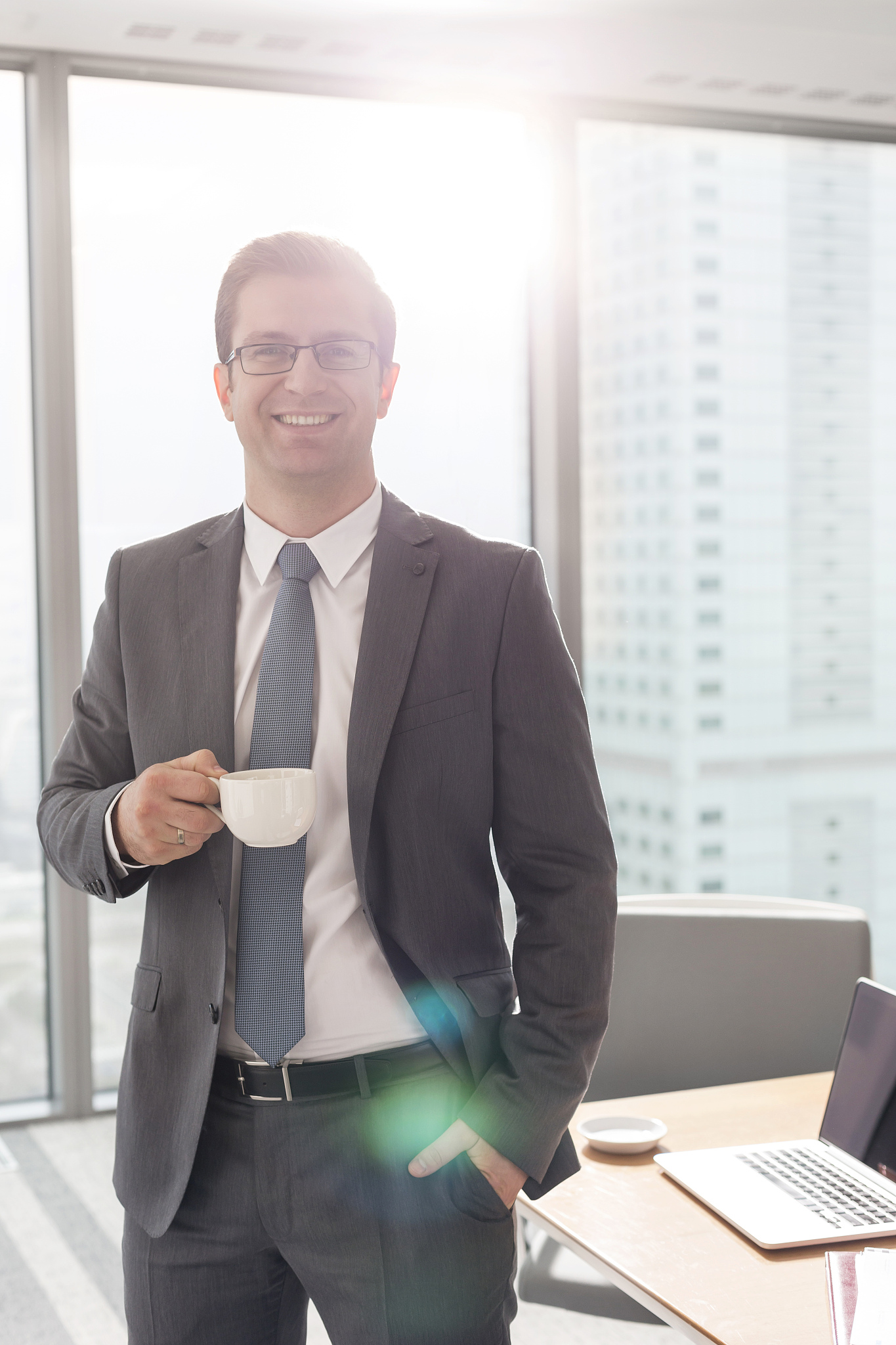portrait of smiling businessman standing with coffee cup in boar