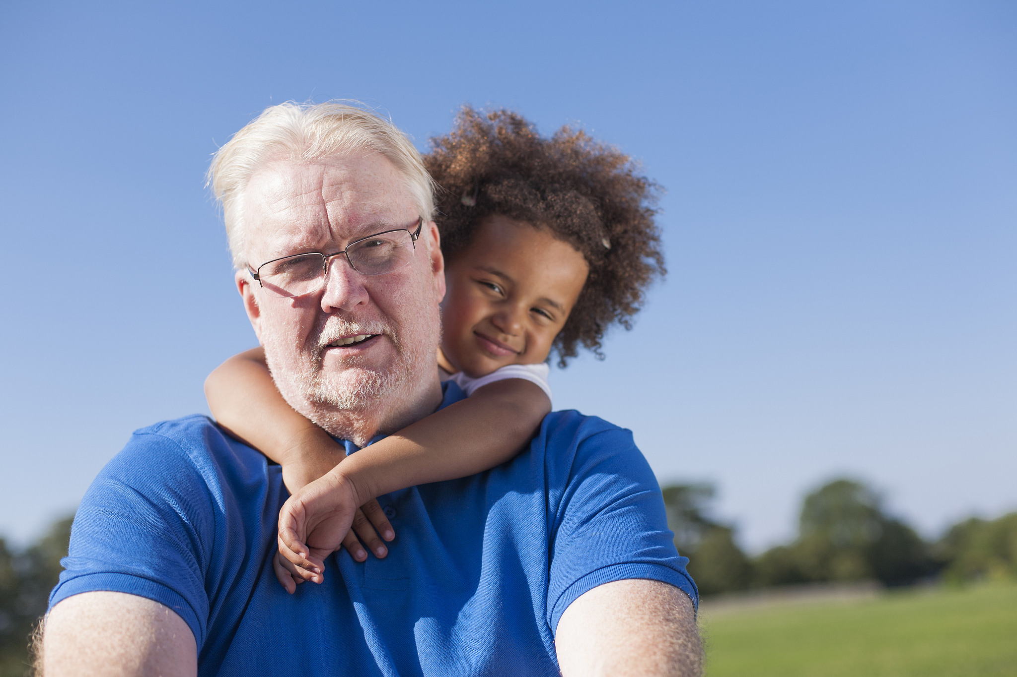 girl hugging grandfather outdoors