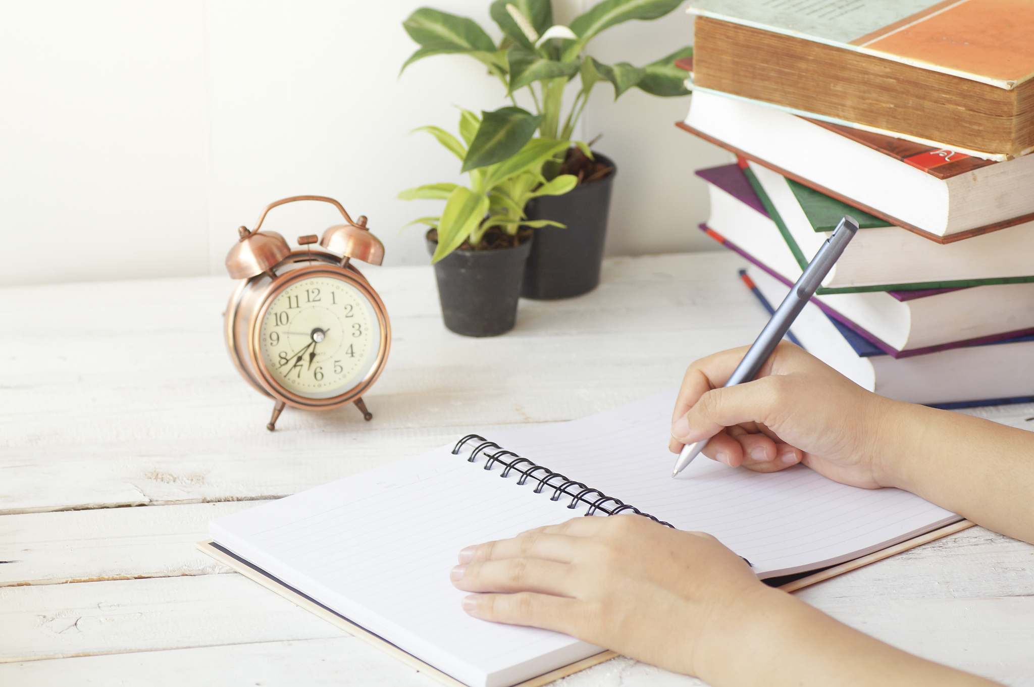 hand writing paper on desk and work place with clock, book and p