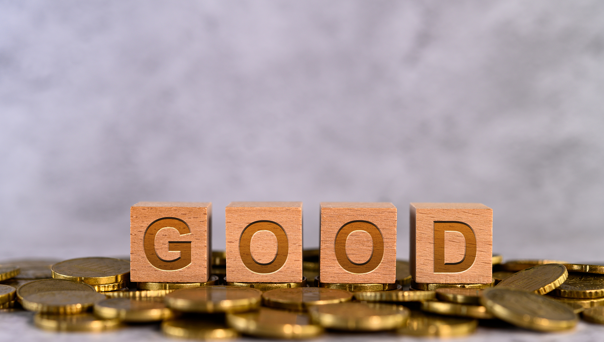 good word alphabet wooden cube letters placed on a gold coin