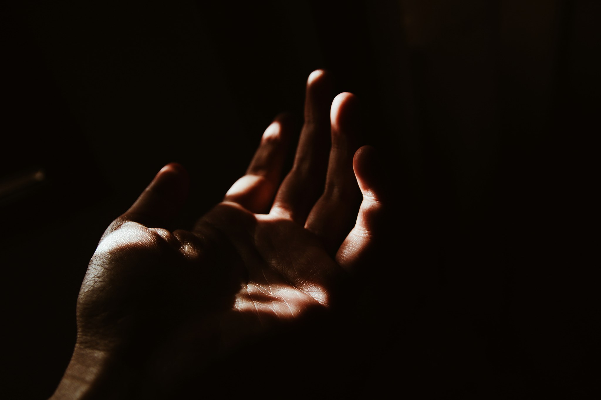close-up of hand against black background