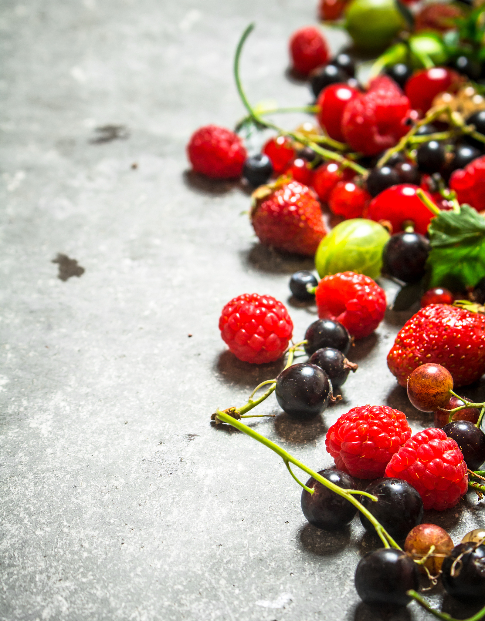 different berries on the stone table.