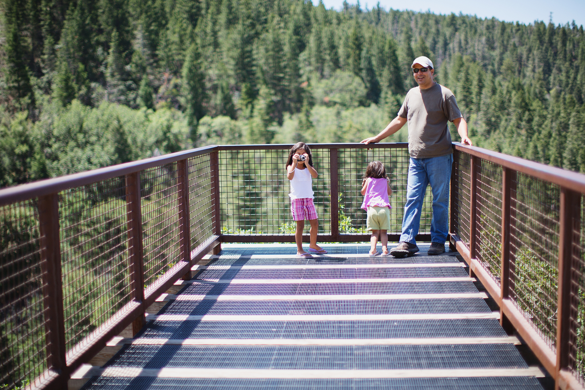 father and daughters on boardwalk sightseeing
