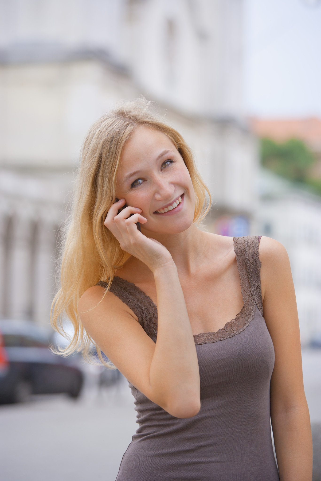 germany, bavaria, munich, young woman talking on phone in front 