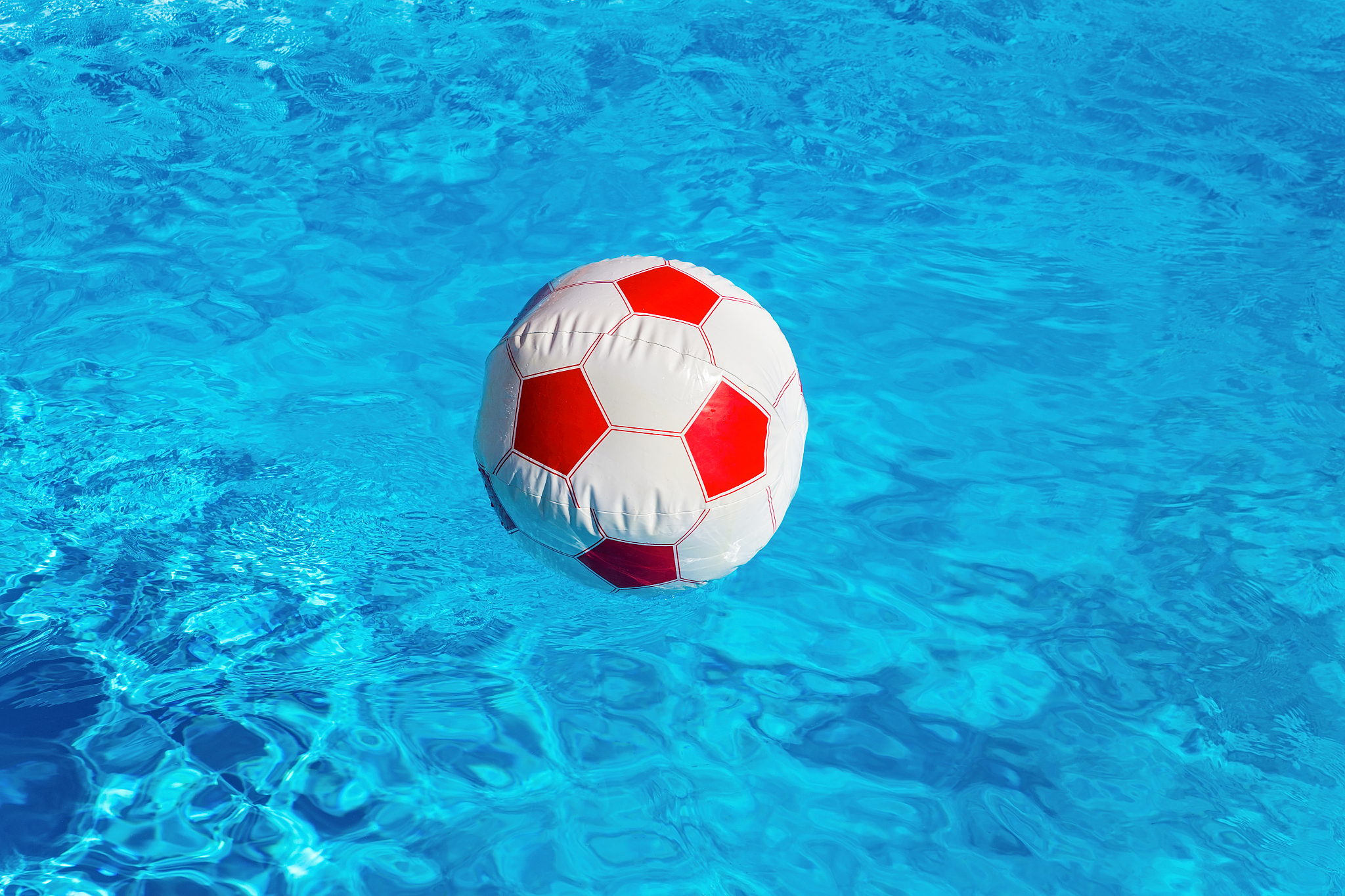 beach ball floating  in blue swimming pool