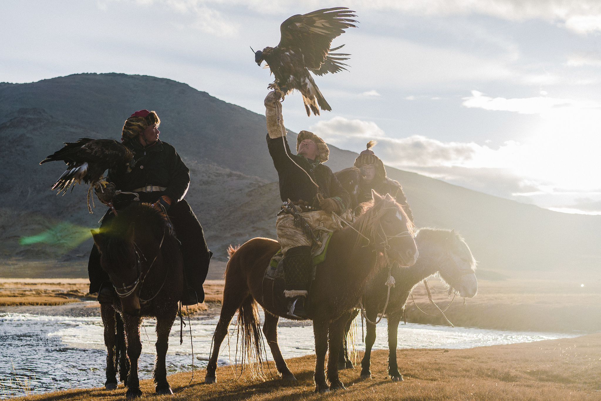 portrait of group of eagle hunters near the river in mongolia