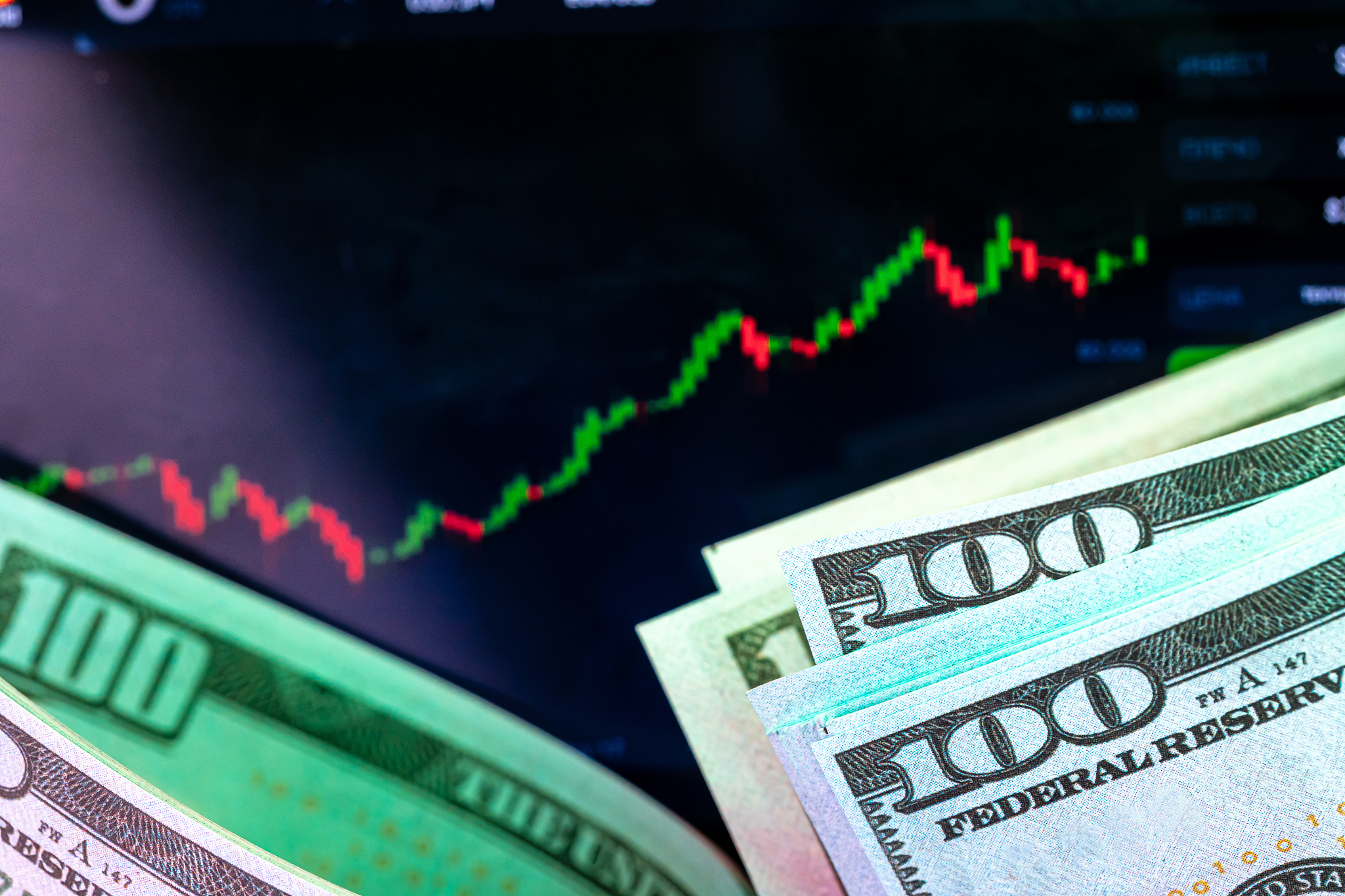 dollars in front of a monitor with a price chart. forex and trad