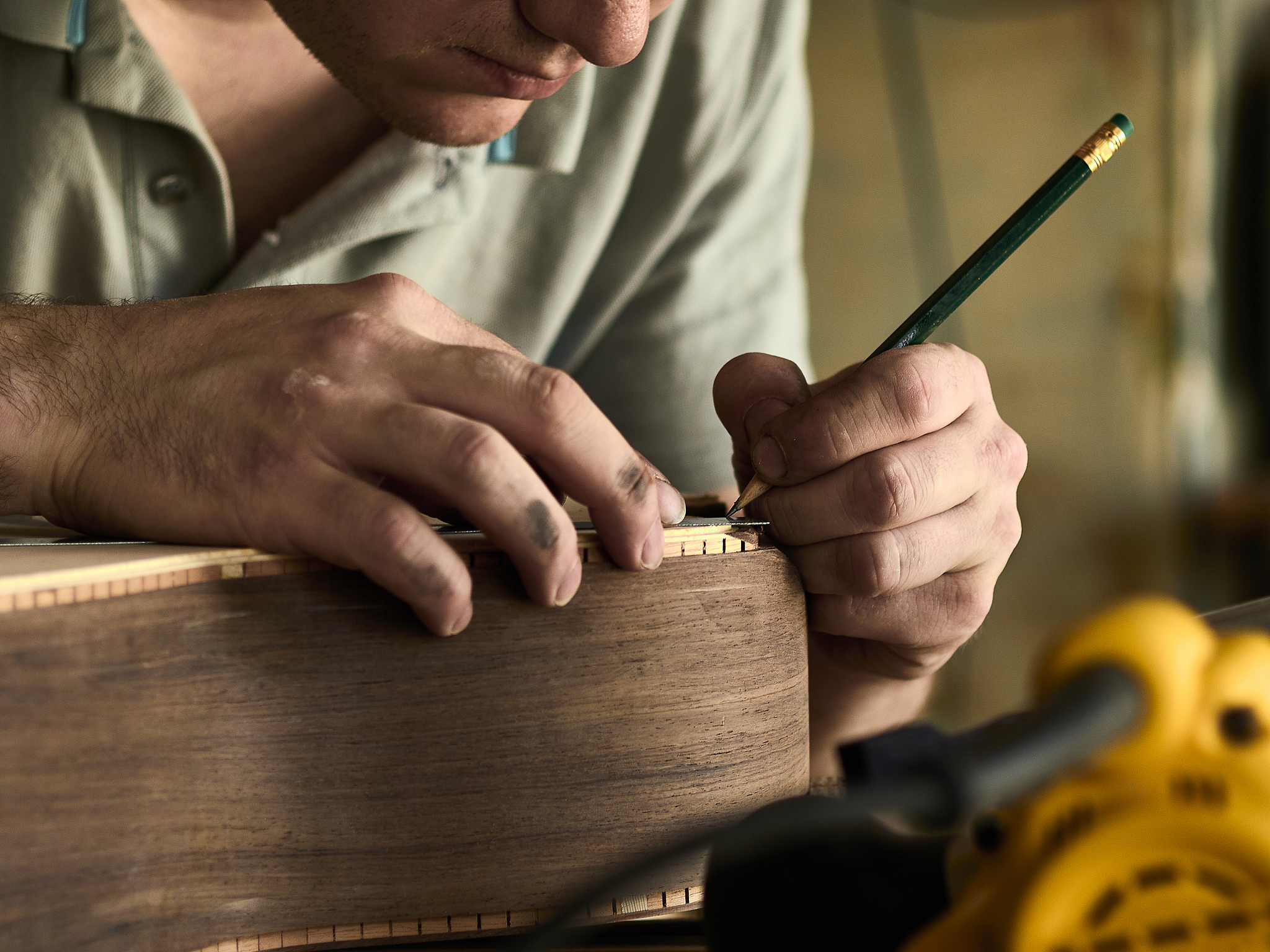 luthier install binding on an guitar. chamfering on the body of 