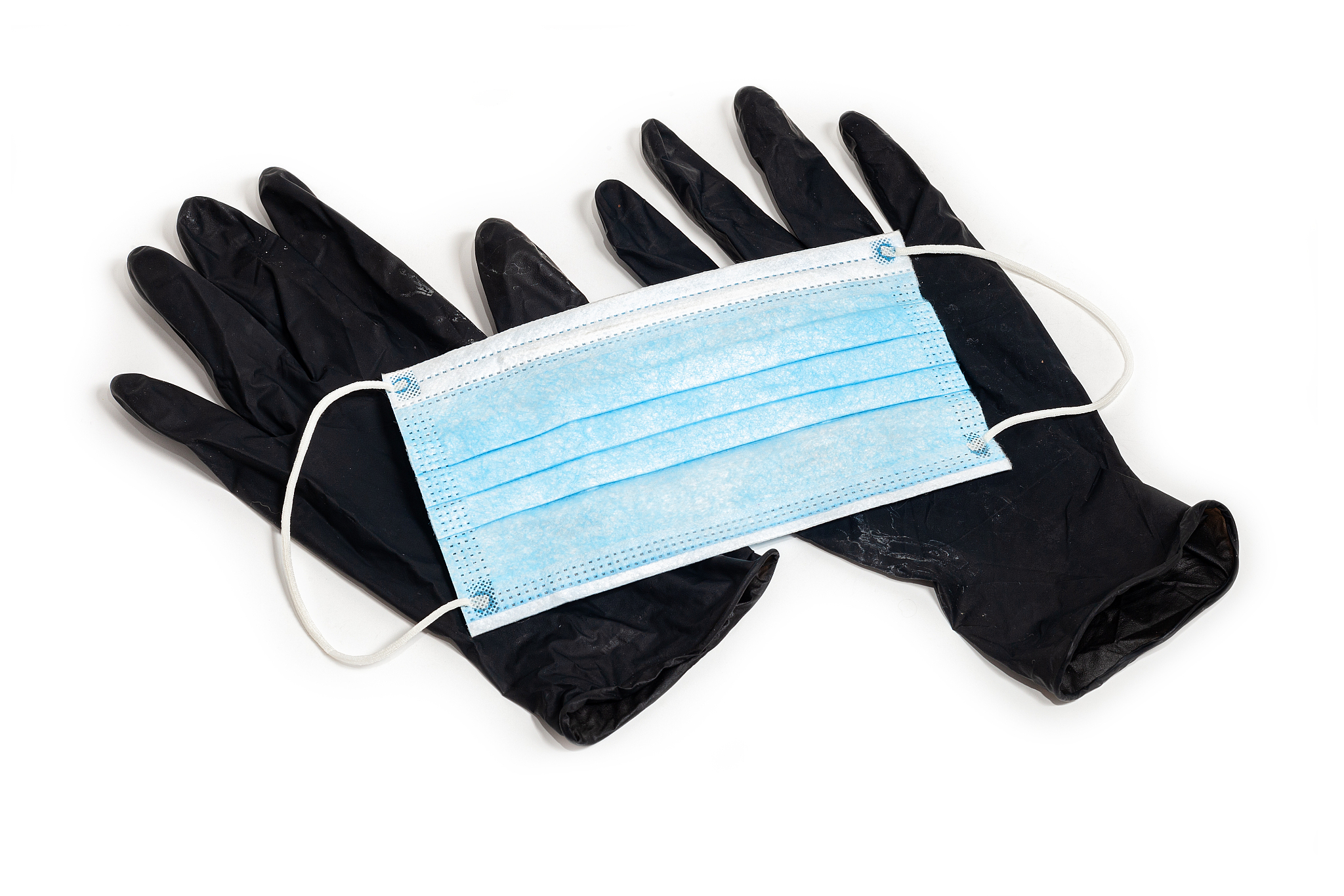 a pair of thin black latex gloves and medical face shield on a w