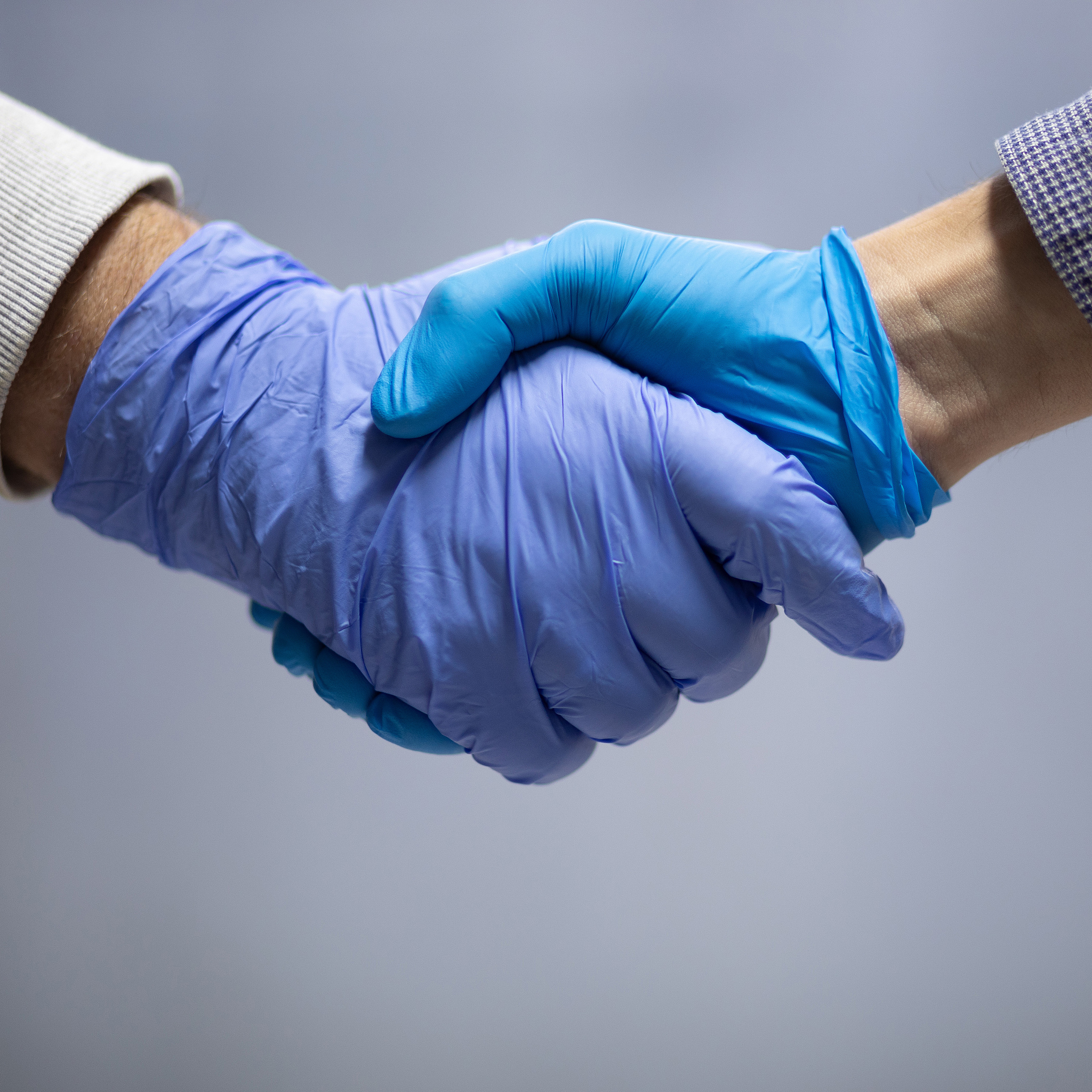 handshaking with blue protective gloves