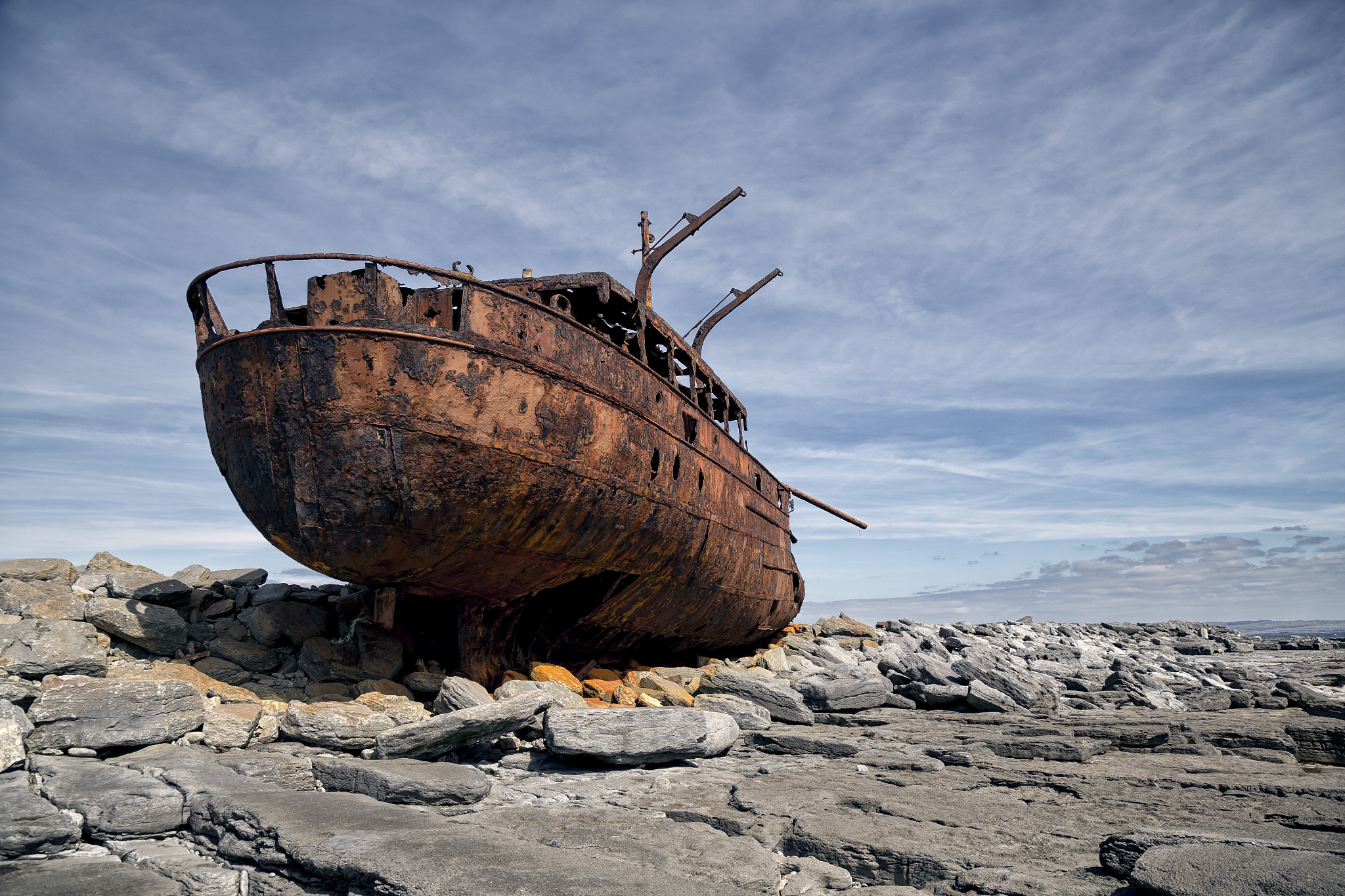 abandoned ship at beach against sky