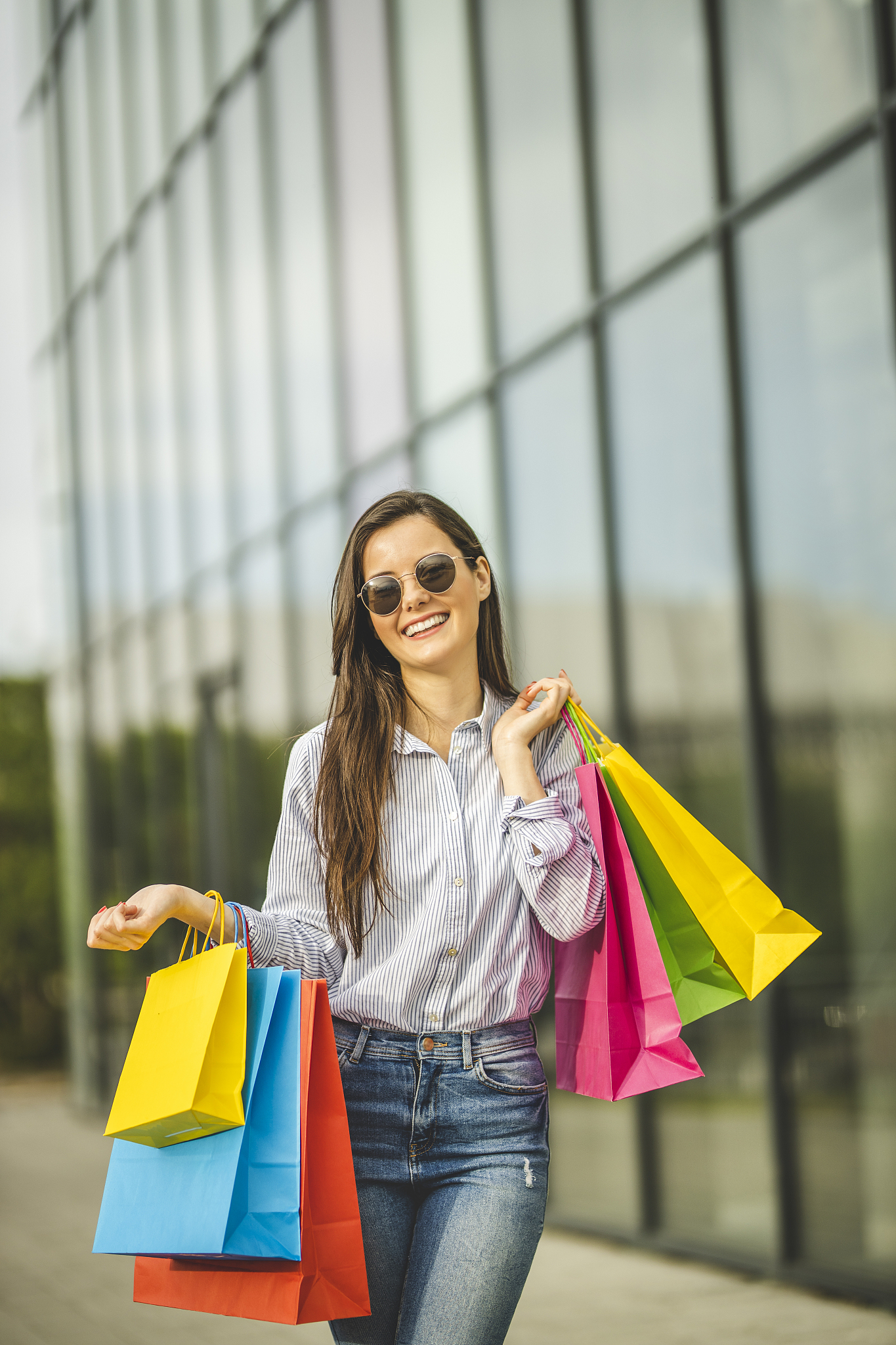 young beautiful woman carrying shopping bags and walking