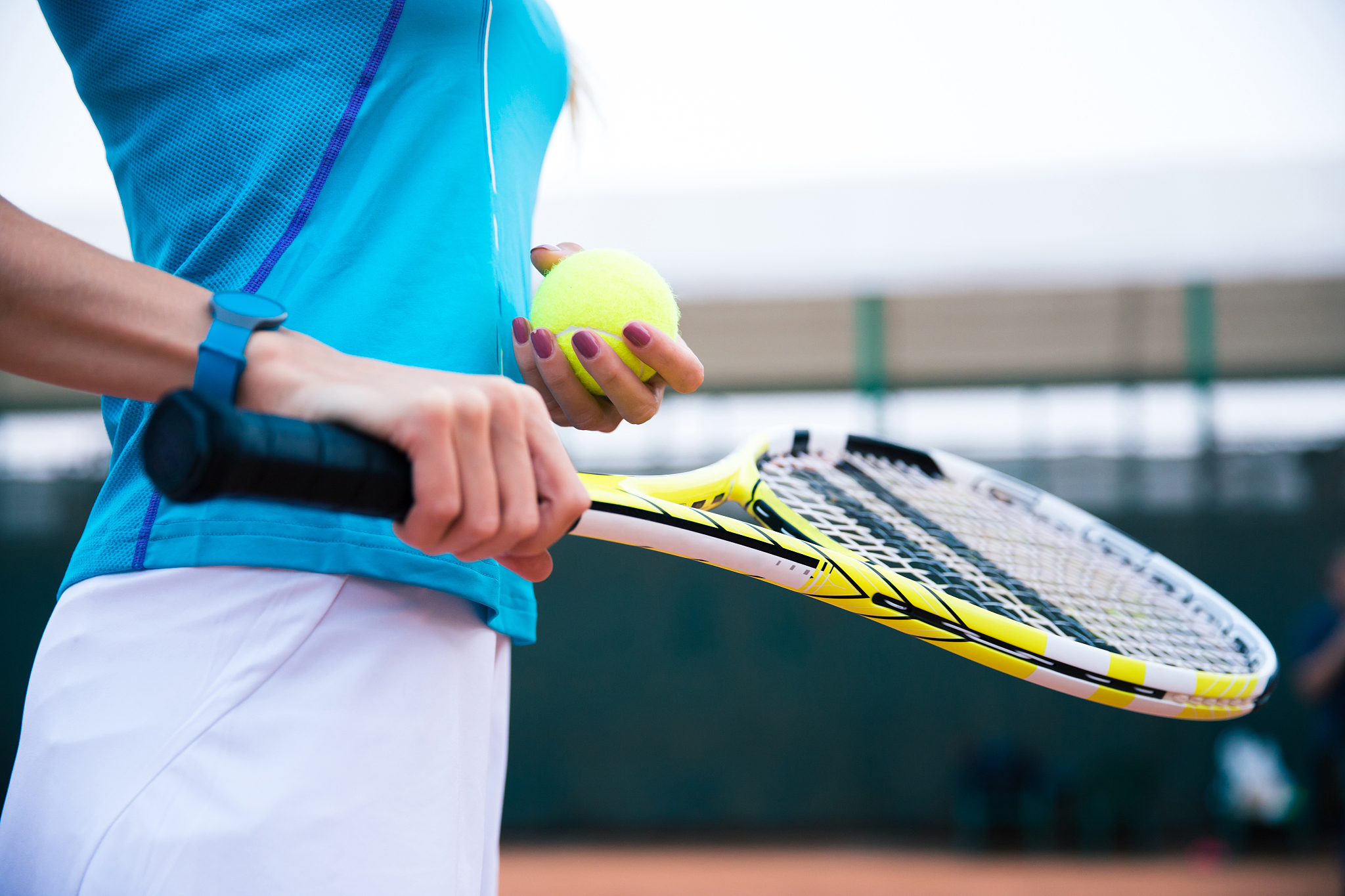 female tennis player holding racket and ball