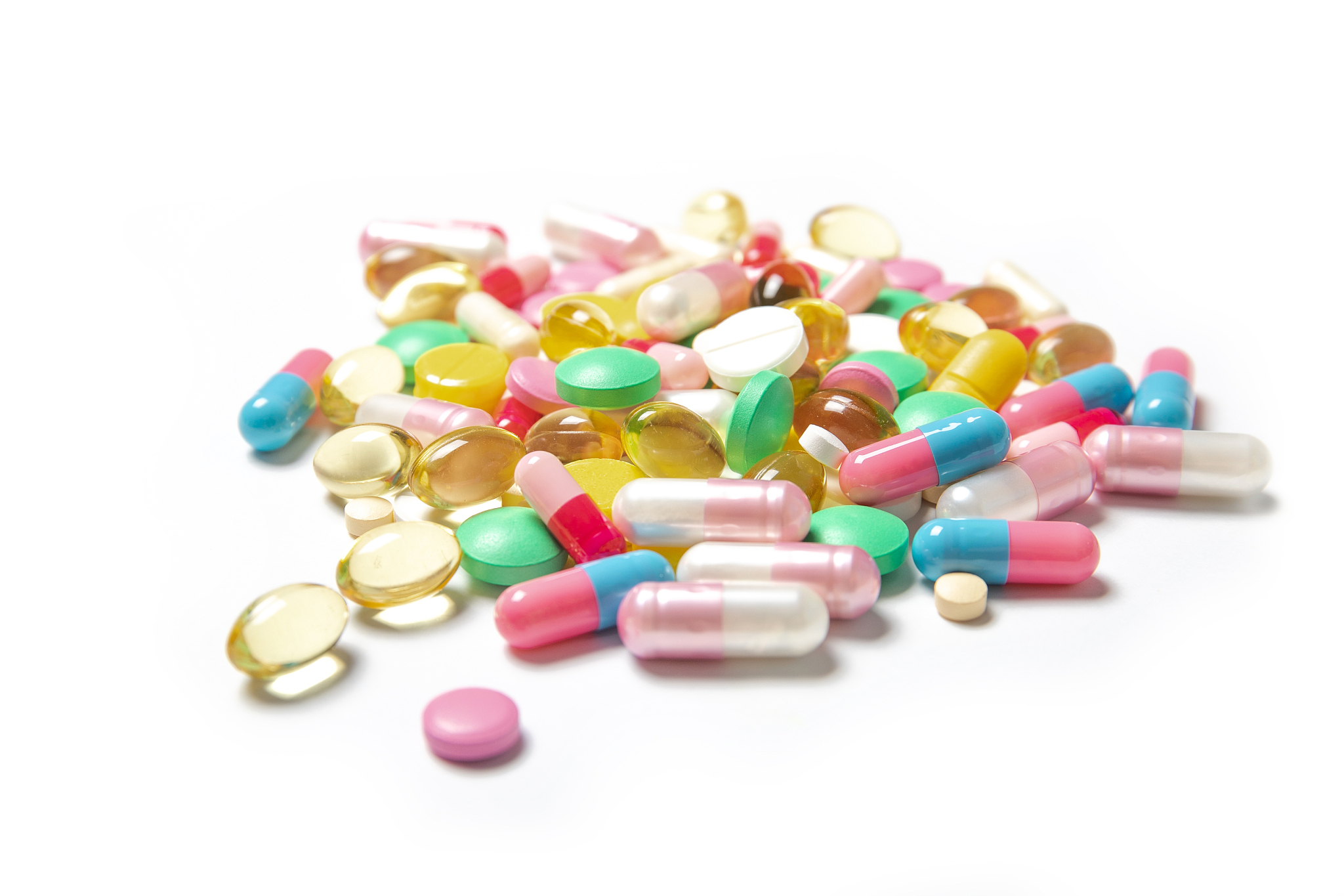 many colored pills on a white background