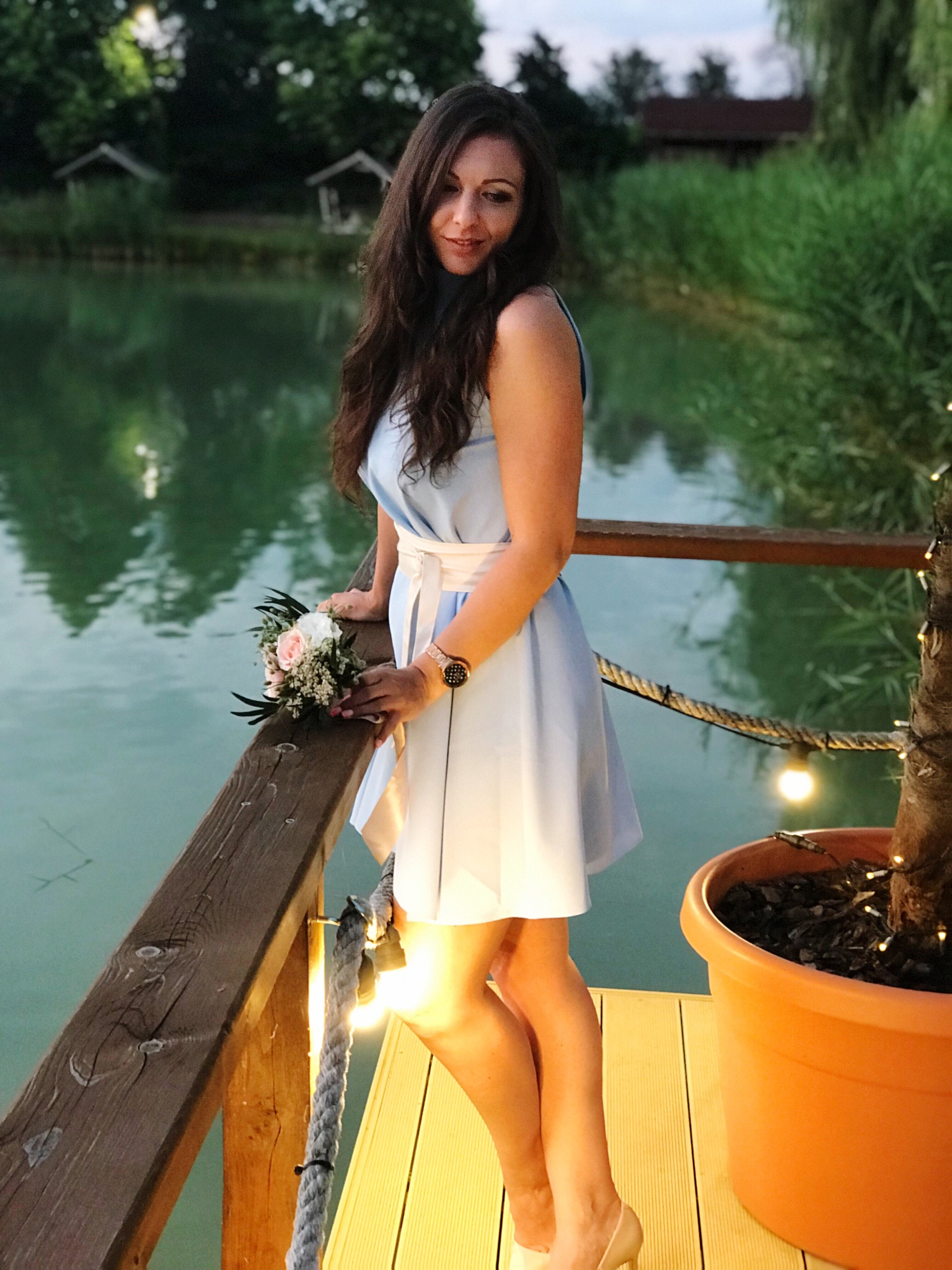 beautiful woman standing by railing against lake