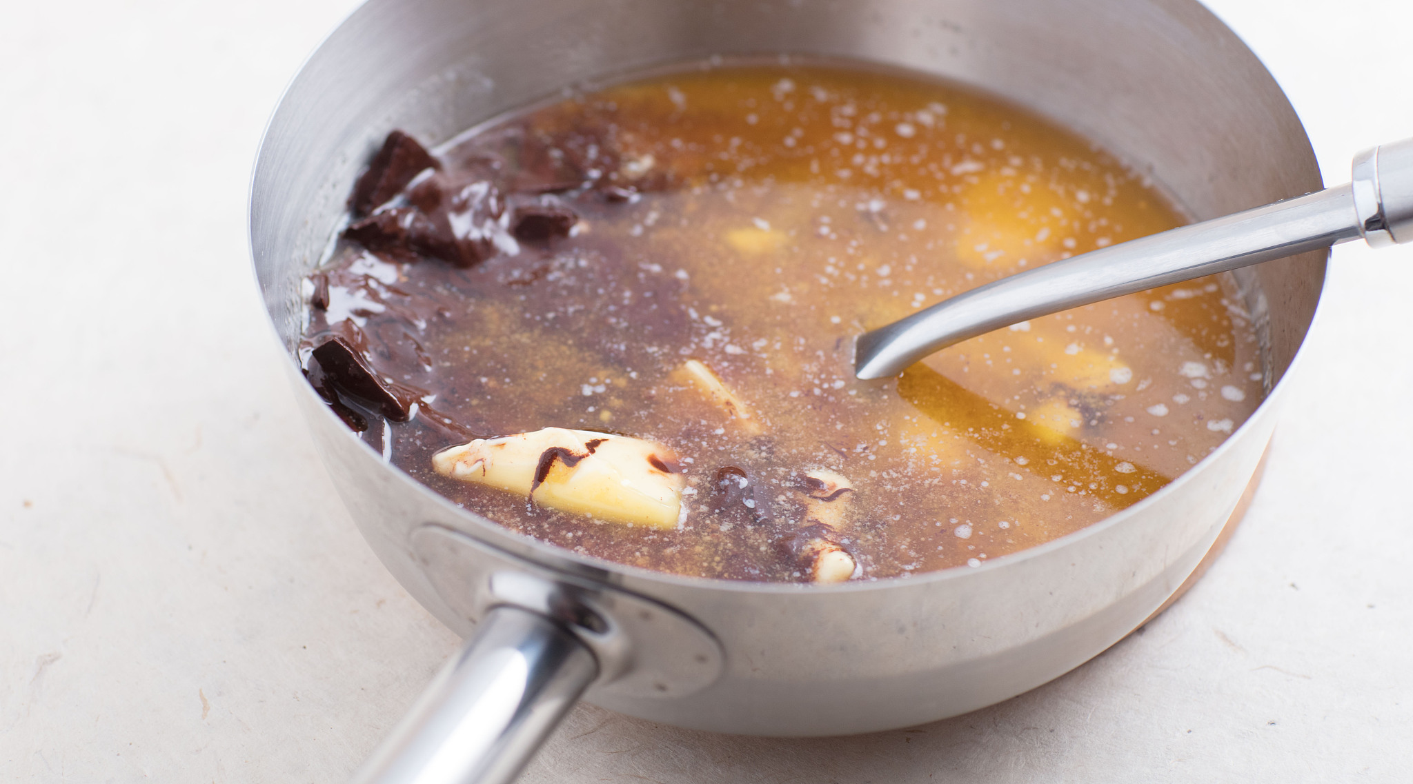 sauce pan with mixture melted butter and melted chocolate.